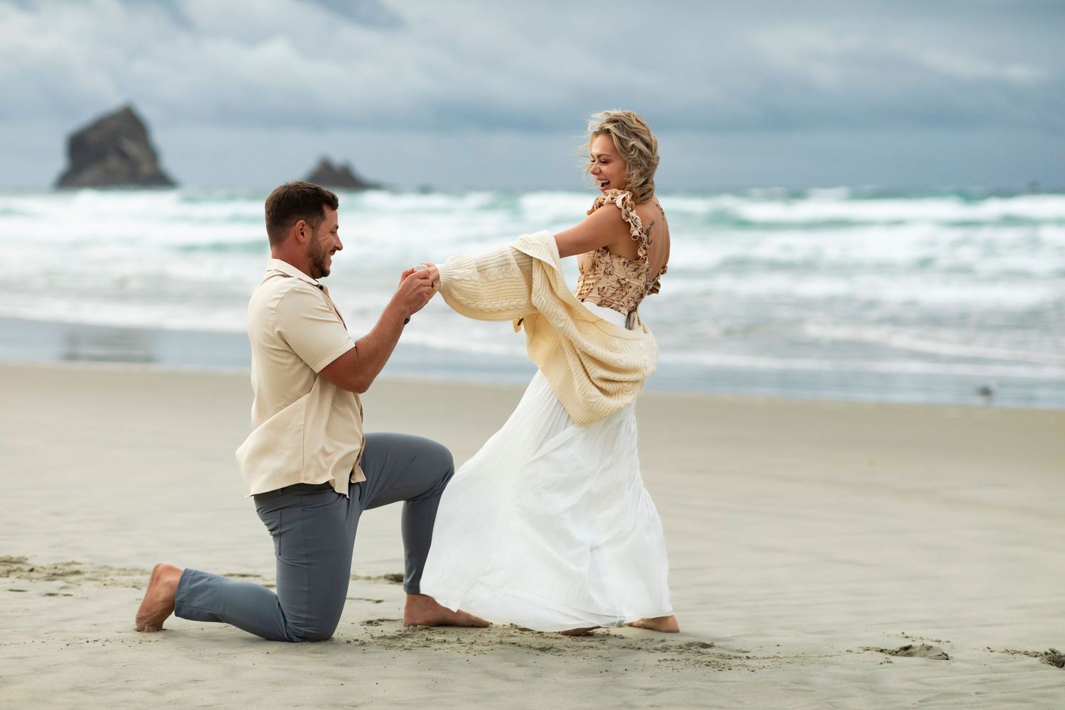 destination photoshoot of beach engagement new zealand man on one knee
