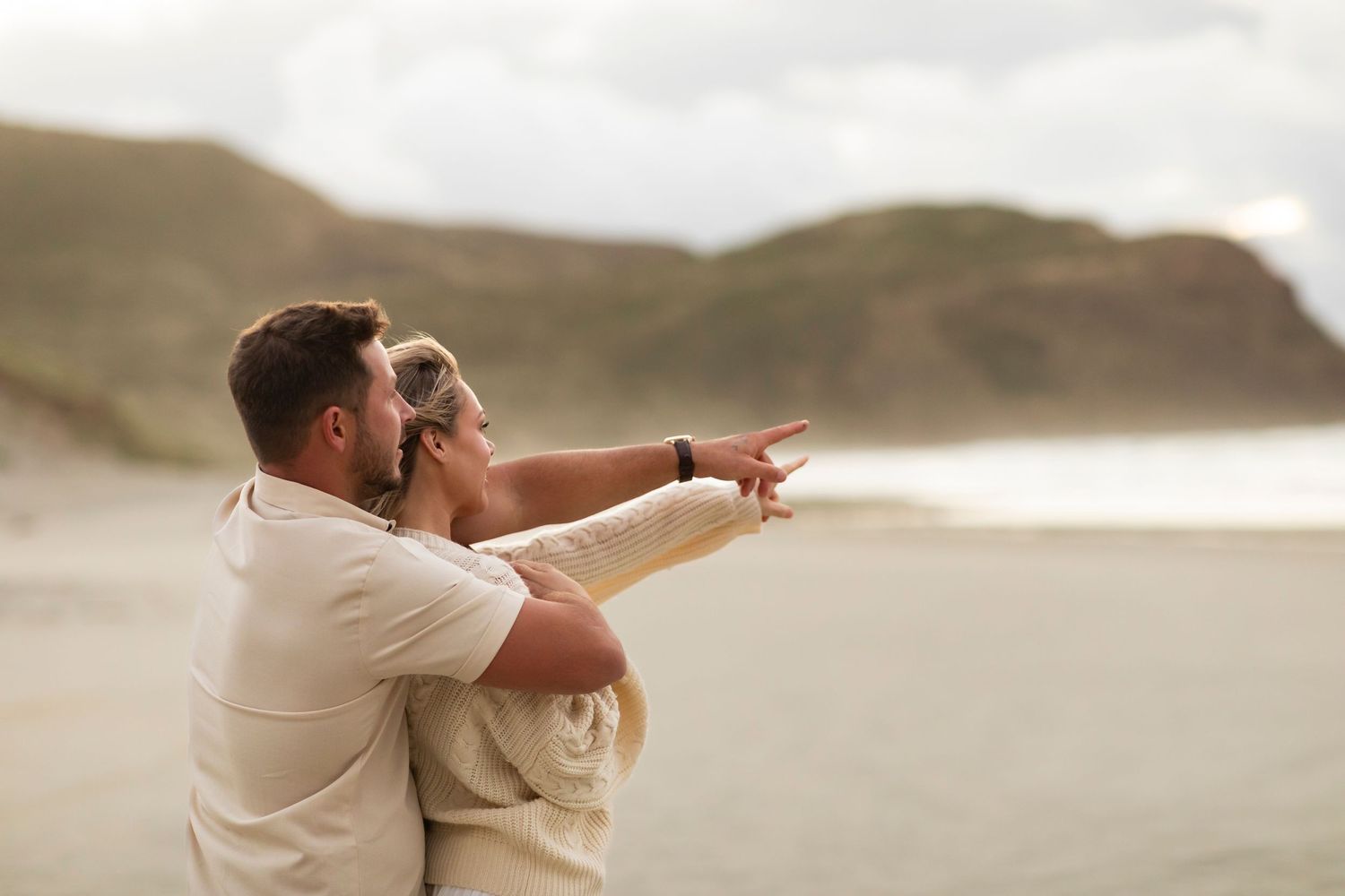 couple seal watching on beach in new zealand