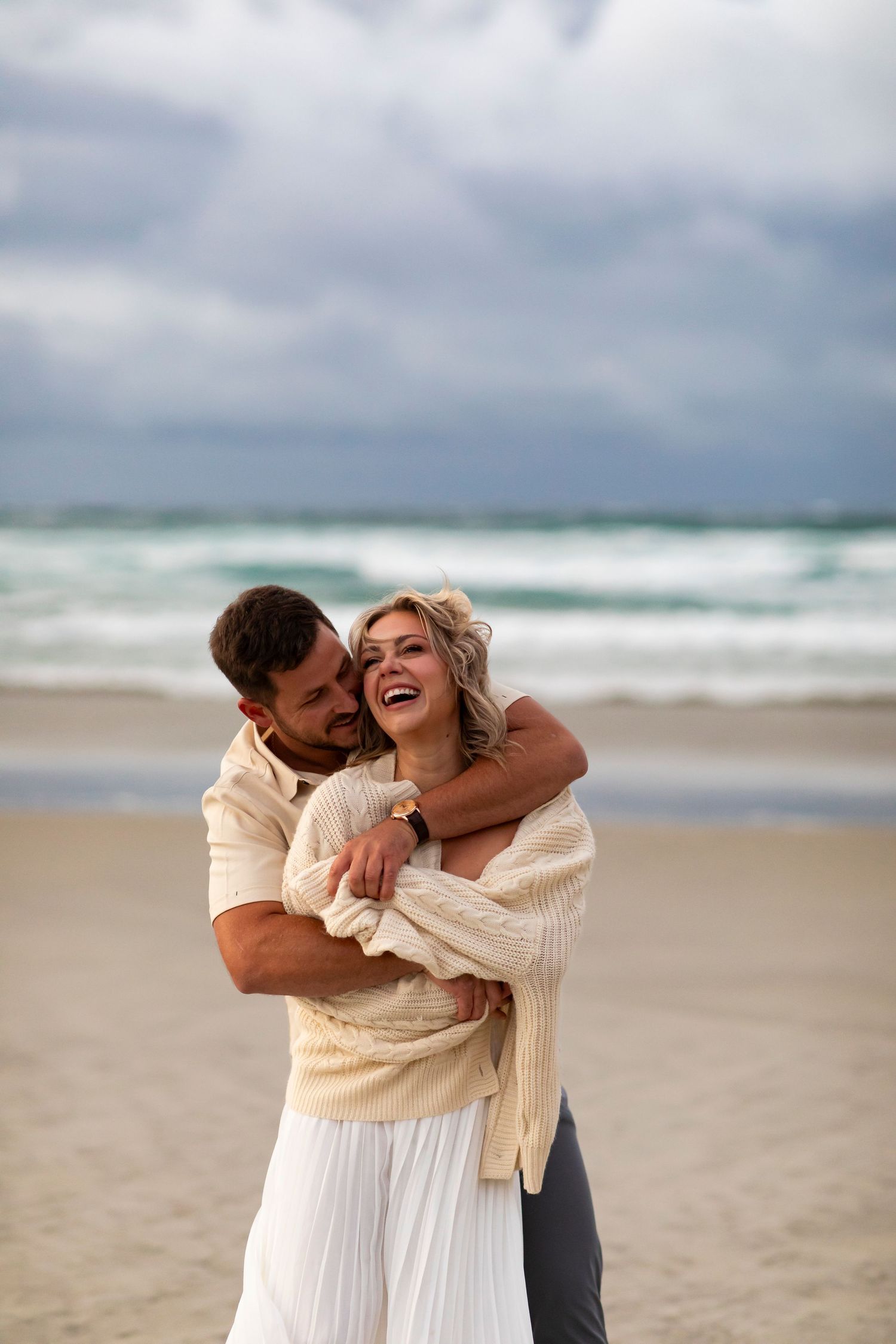 vacation photo of couple on beach in New Zealand in love