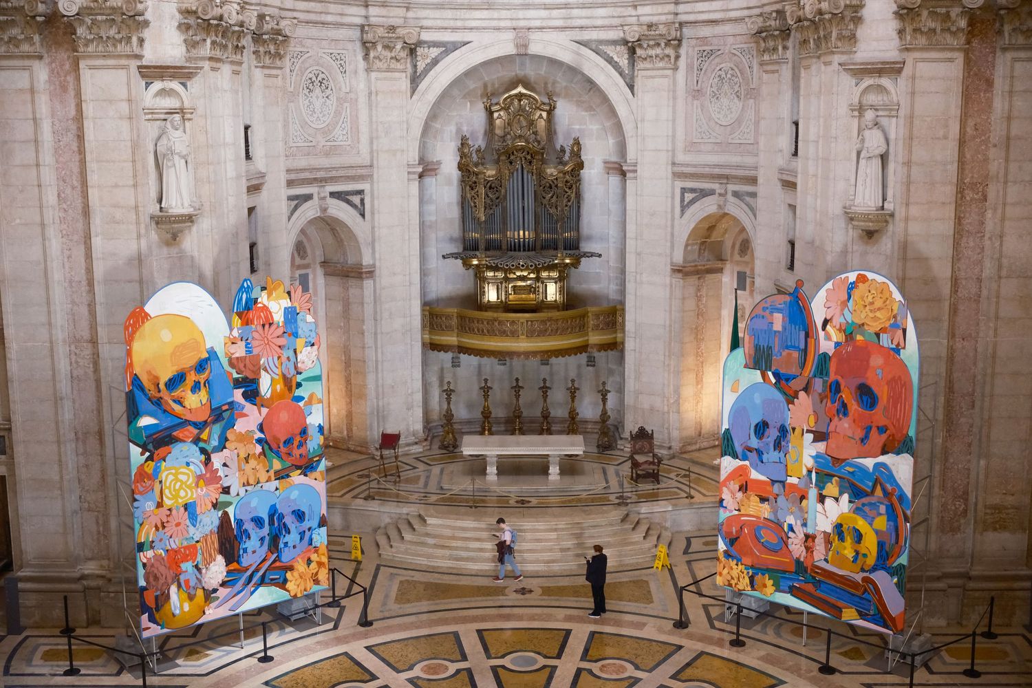 Colorful balloon art installation contrasts with ornate classical architecture inside a grand historic church interior.