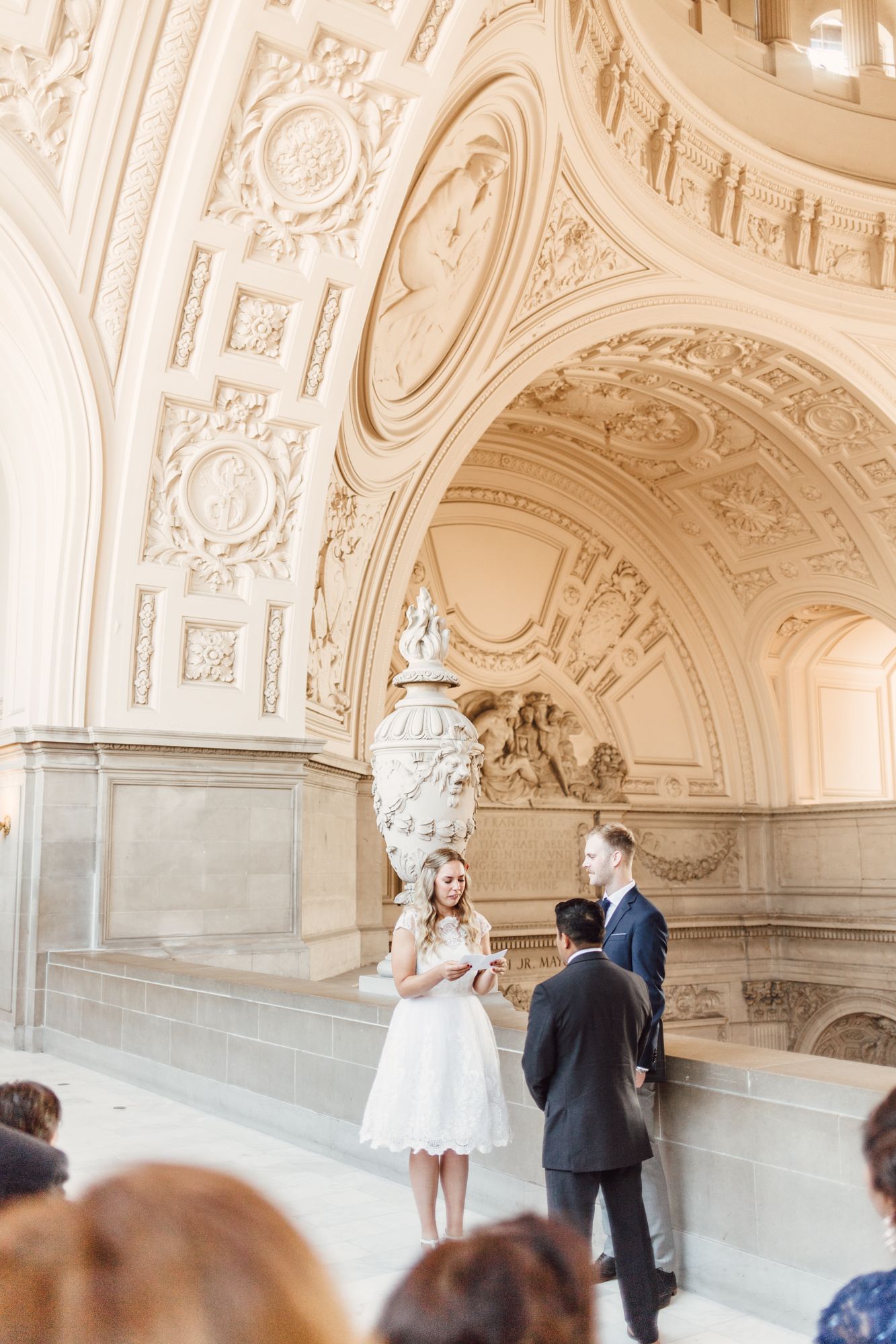 Couple exchanging vows beneath stunning Beaux-Arts architecture at San Francisco City Hall elopement.