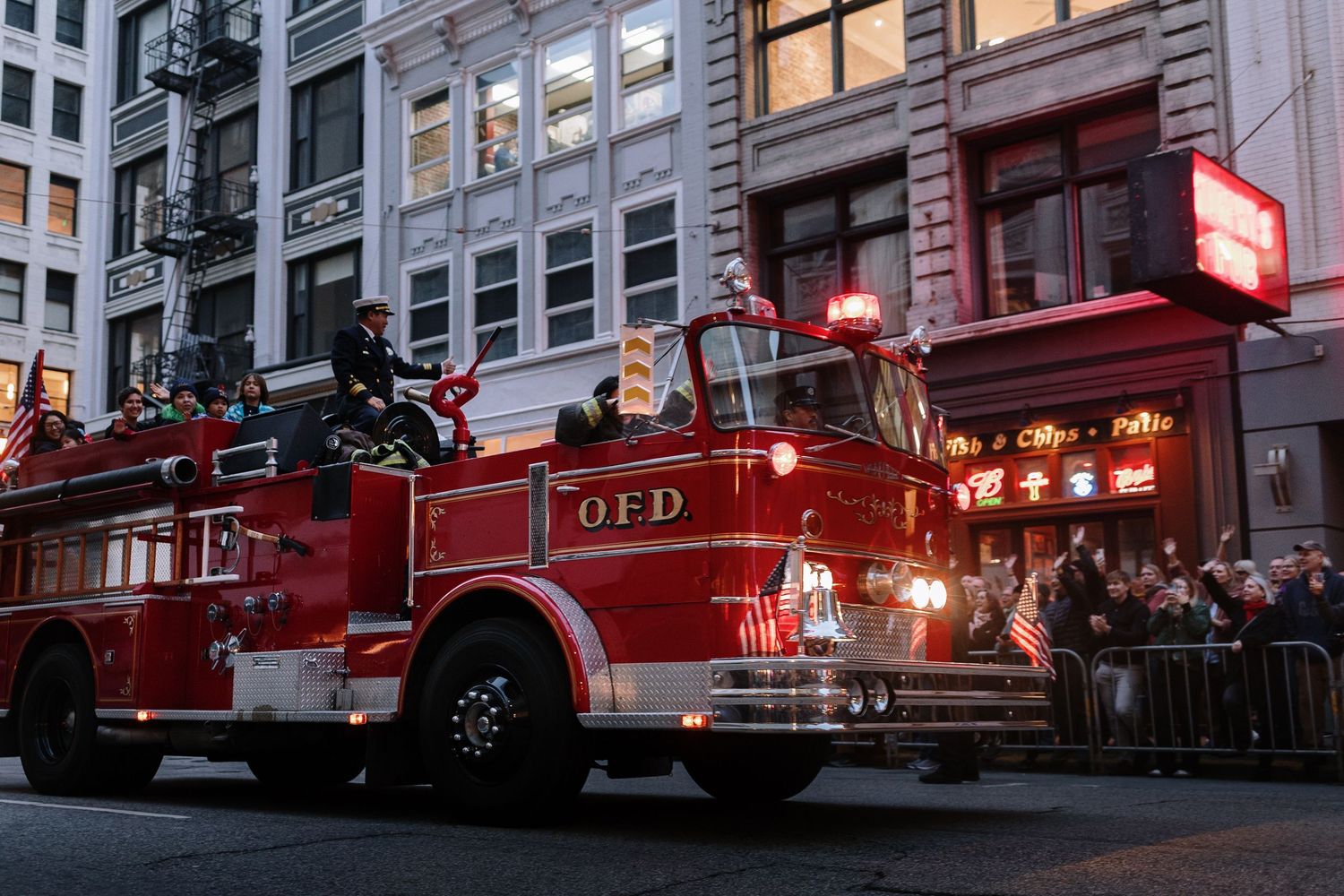 Vintage OFD red fire truck with Santa Claus driving in a city night parade.