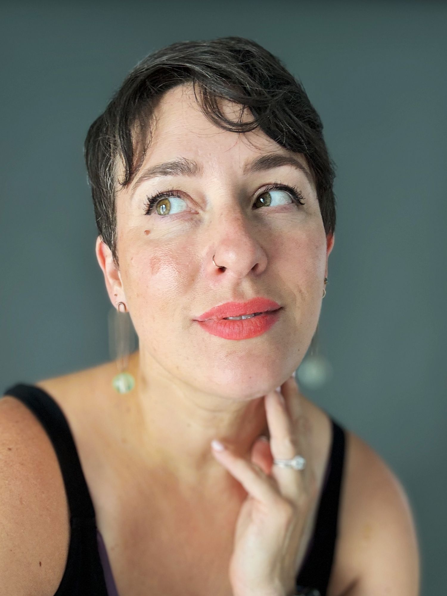 A series of close-up portraits showing playful expressions and bright coral lipstick against a teal background.