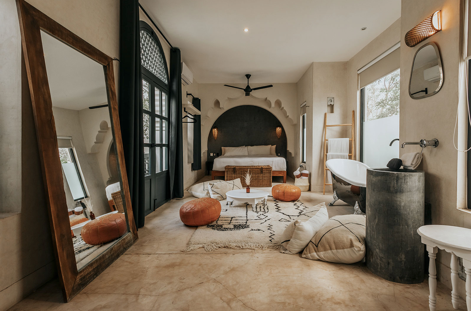 Modern hotel room interior with beige tones, plush bedding, and minimalist decor showcasing floor-to-ceiling windows.