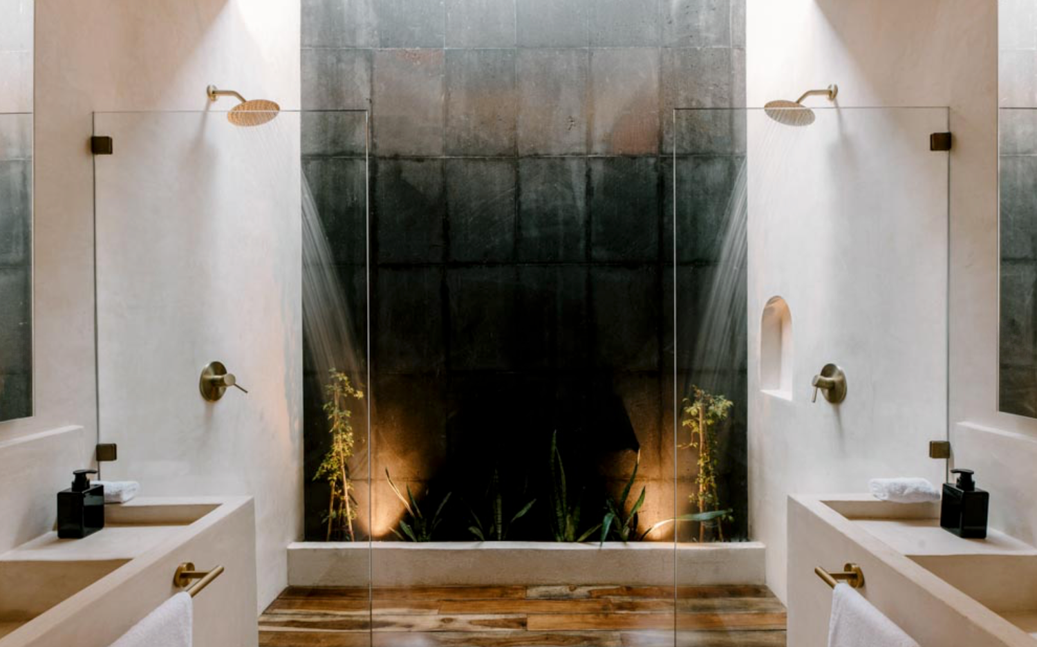 Modern bathroom interior with symmetrical white walls, dual vanities and dramatic dark accent wall with uplighting.