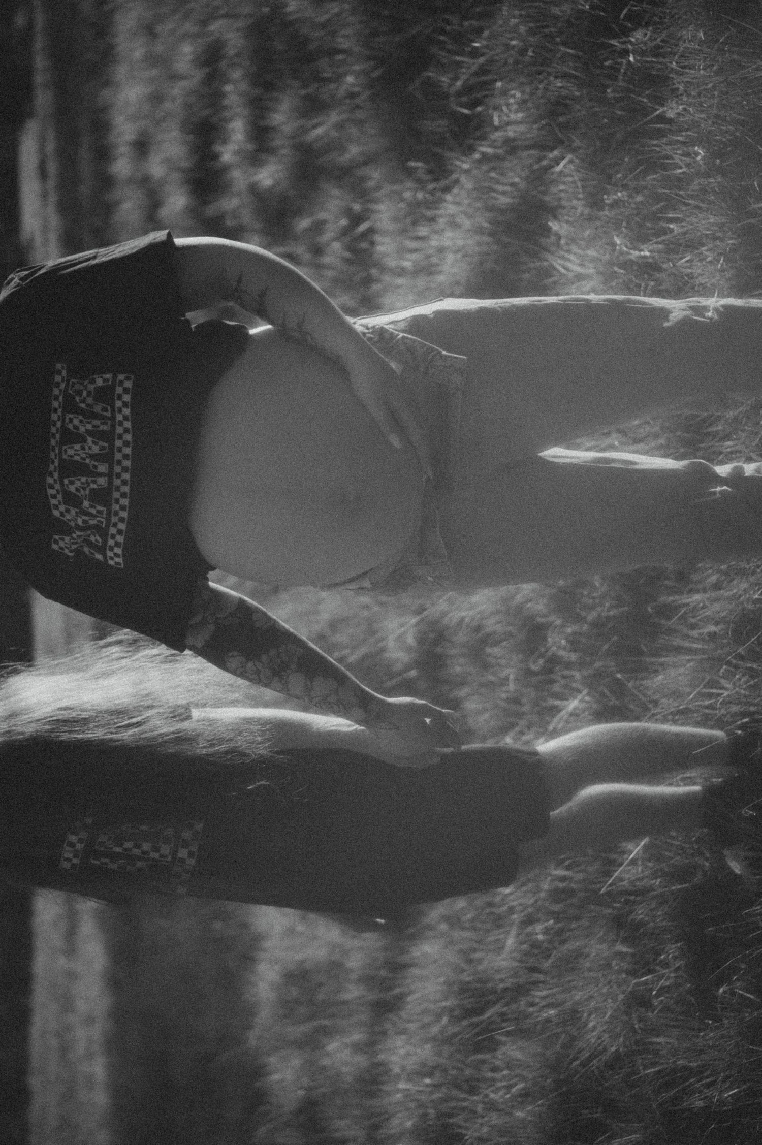 Atmospheric black and white silhouette of a figure in a baseball cap surrounded by swirling mist.