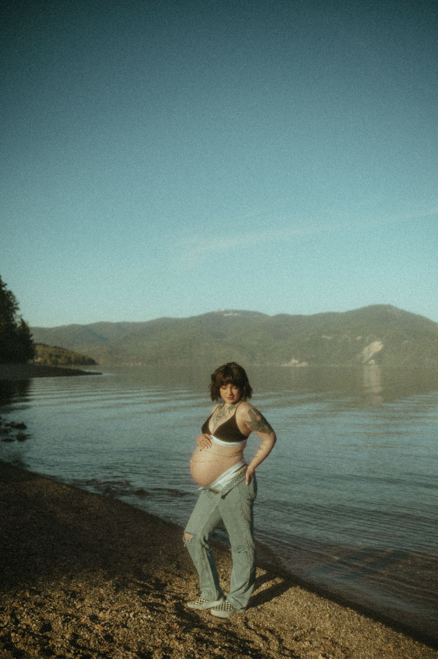 A series of artistic photographs showing a figure dancing and moving on a rocky beach with mountains and water in the background.