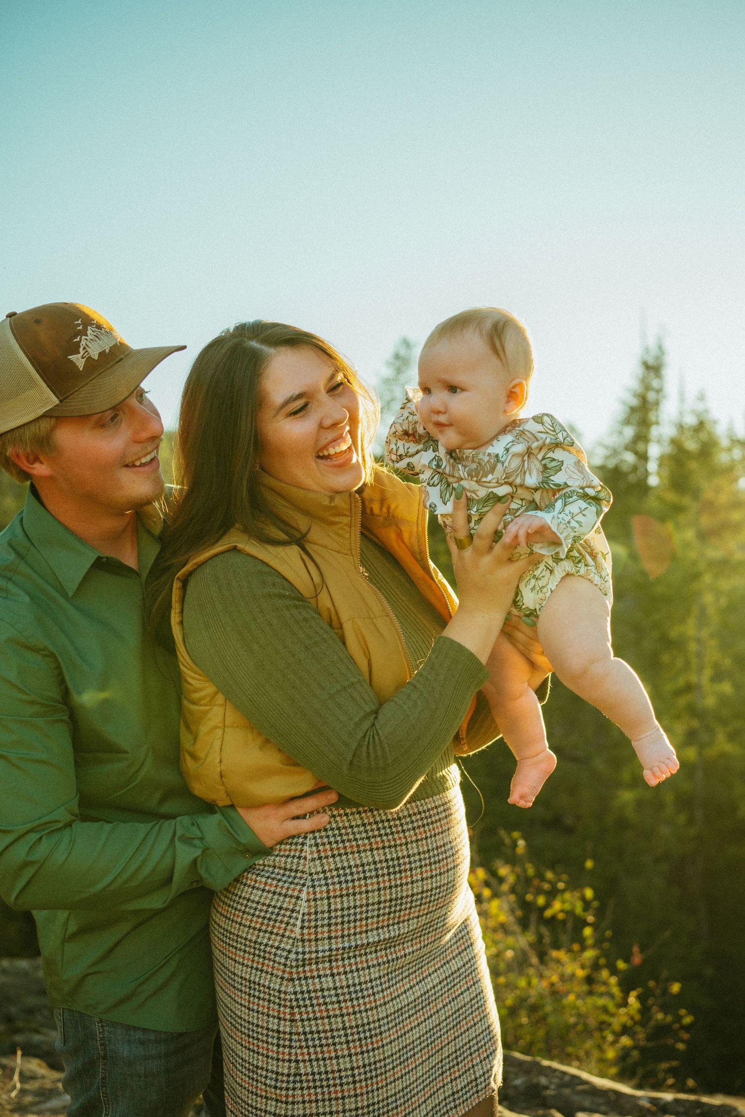 A family enjoys a tender moment together outdoors during golden hour in a natural setting.