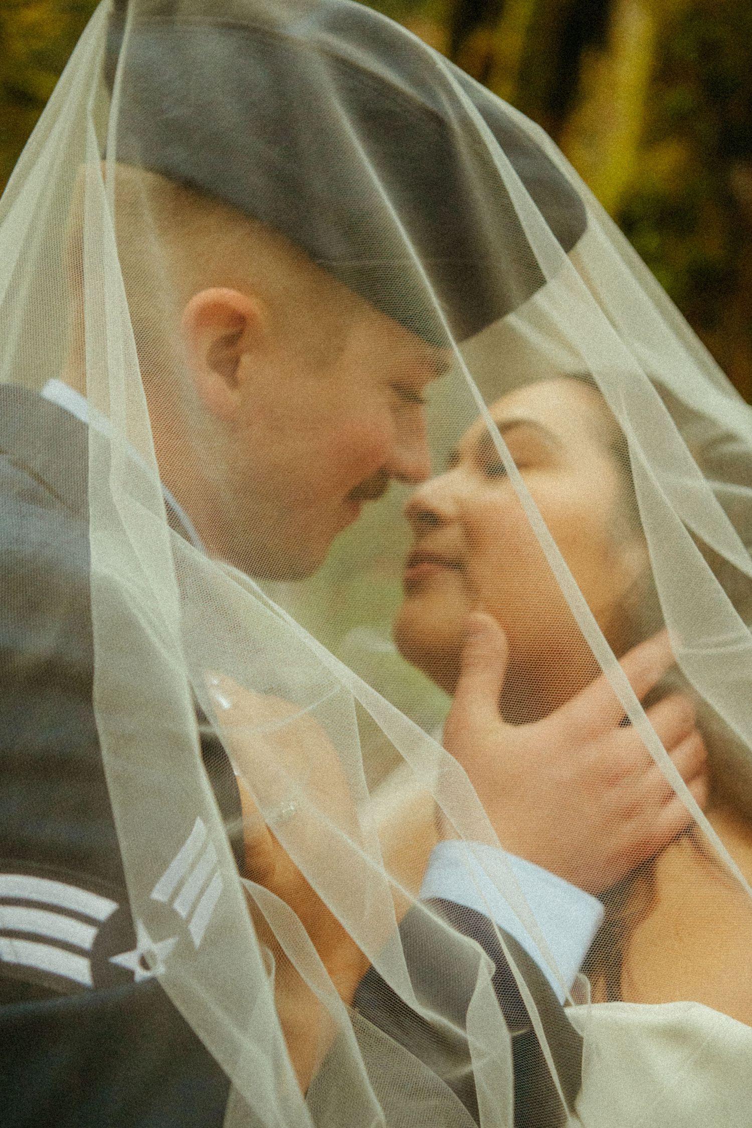 A romantic wedding photo of a couple sharing an intimate moment under a delicate veil.