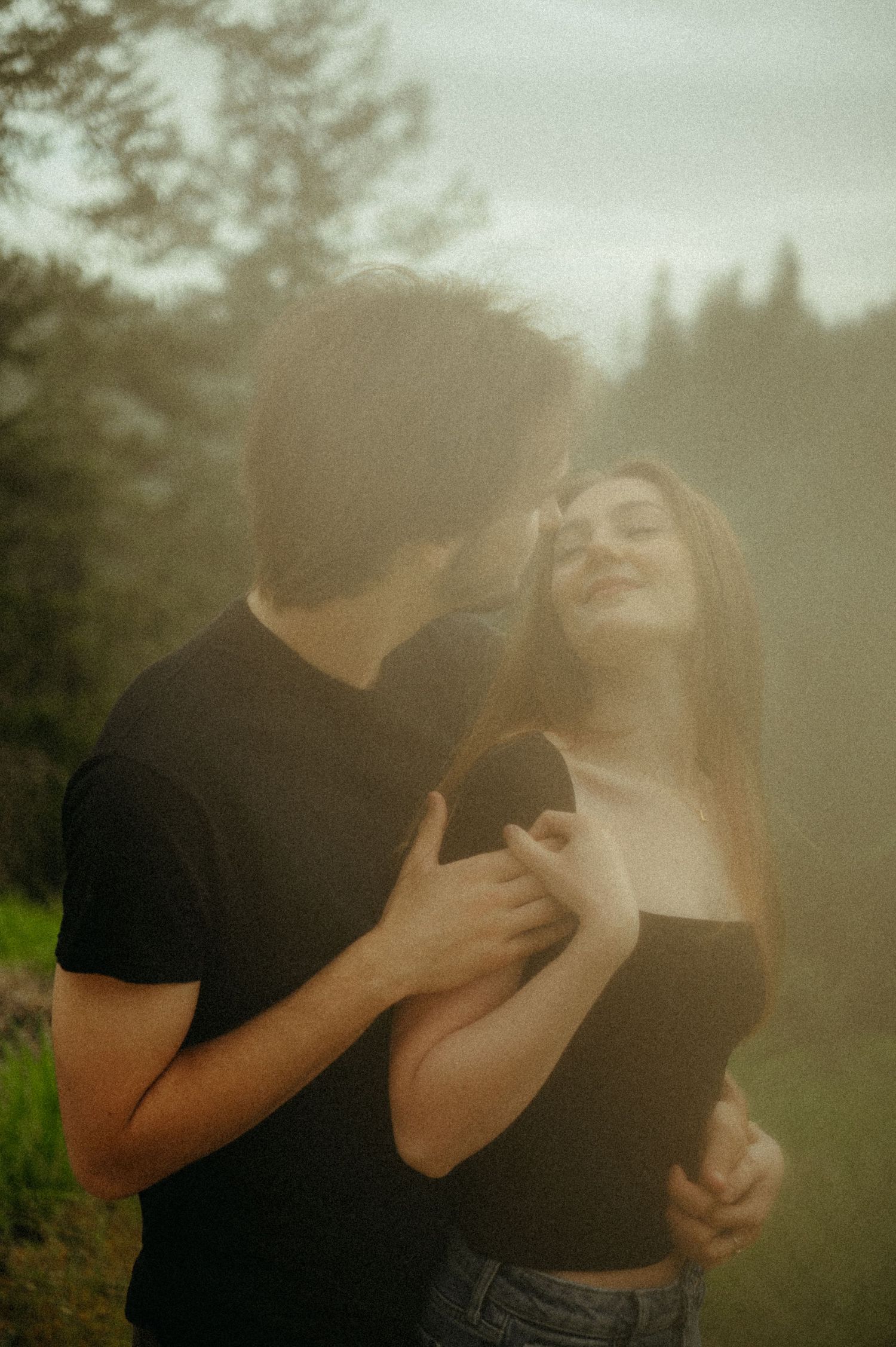Artistic sequence of two people embracing in a dreamy outdoor setting with soft natural lighting and misty atmosphere.