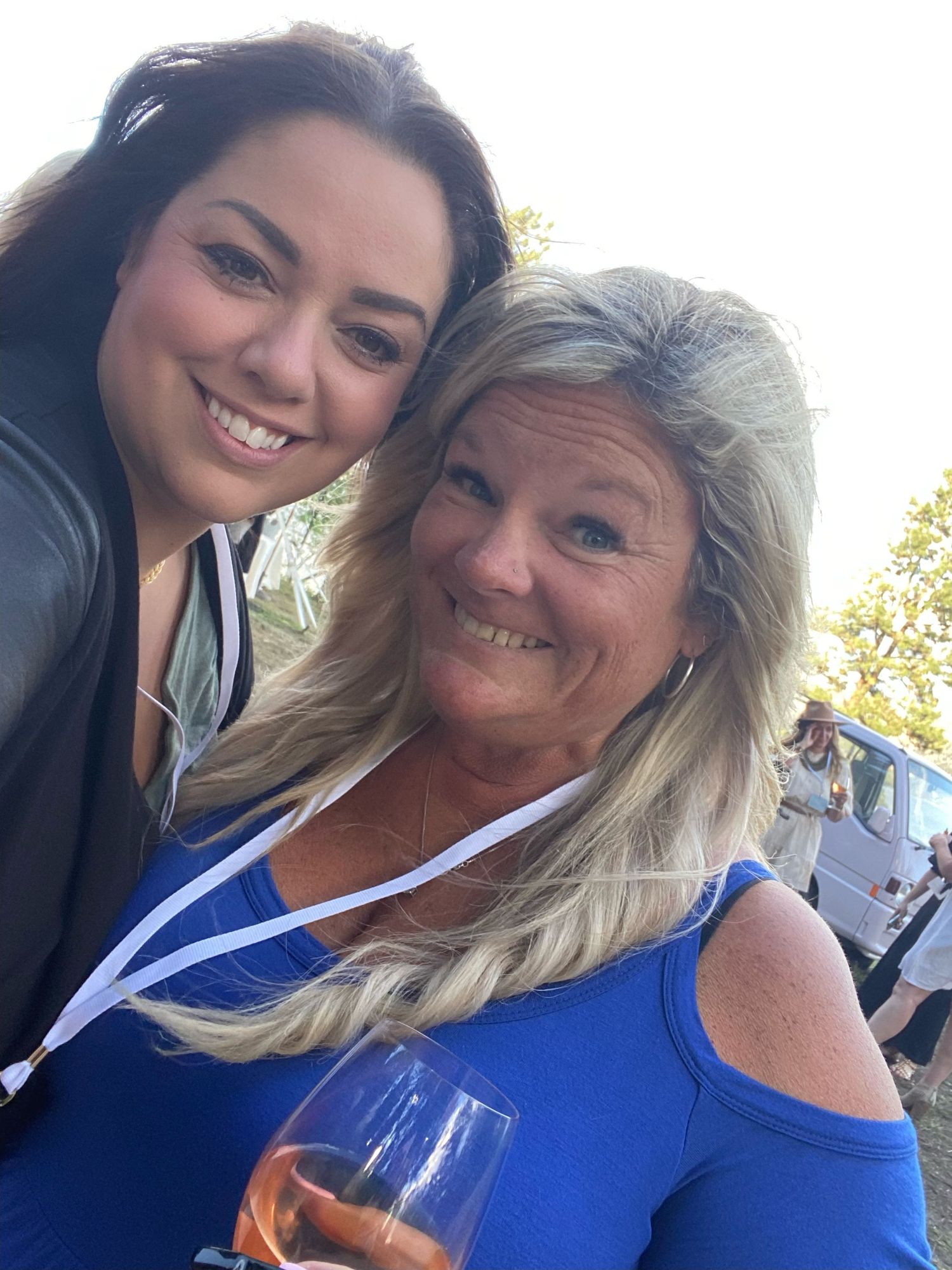 Two people smile together in a series of selfies while wearing blue clothing outdoors on a sunny day.