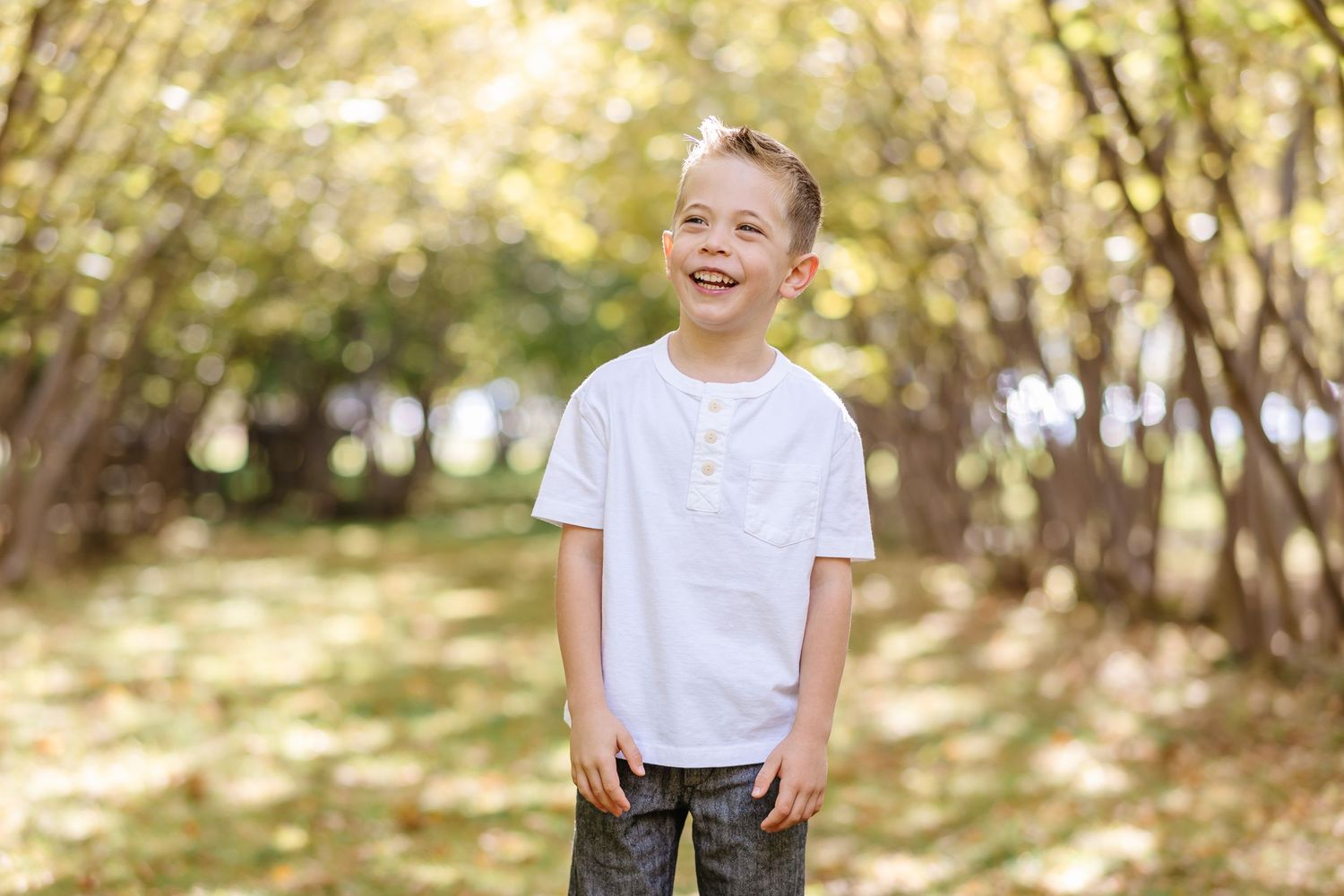 A series of candid outdoor photos showing joyful expressions and natural poses in a sunlit wooded setting.