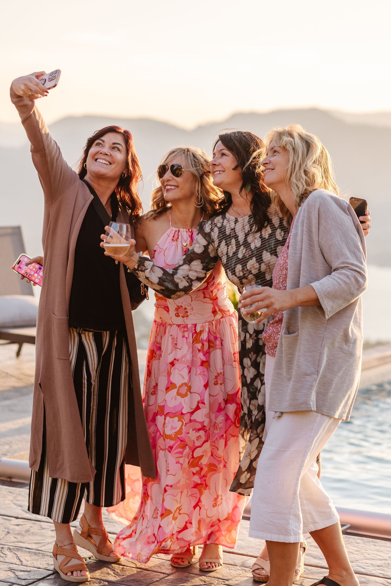 A group of friends taking a selfie together while enjoying drinks at sunset for the build your brave retreat located in Osoyoos bc