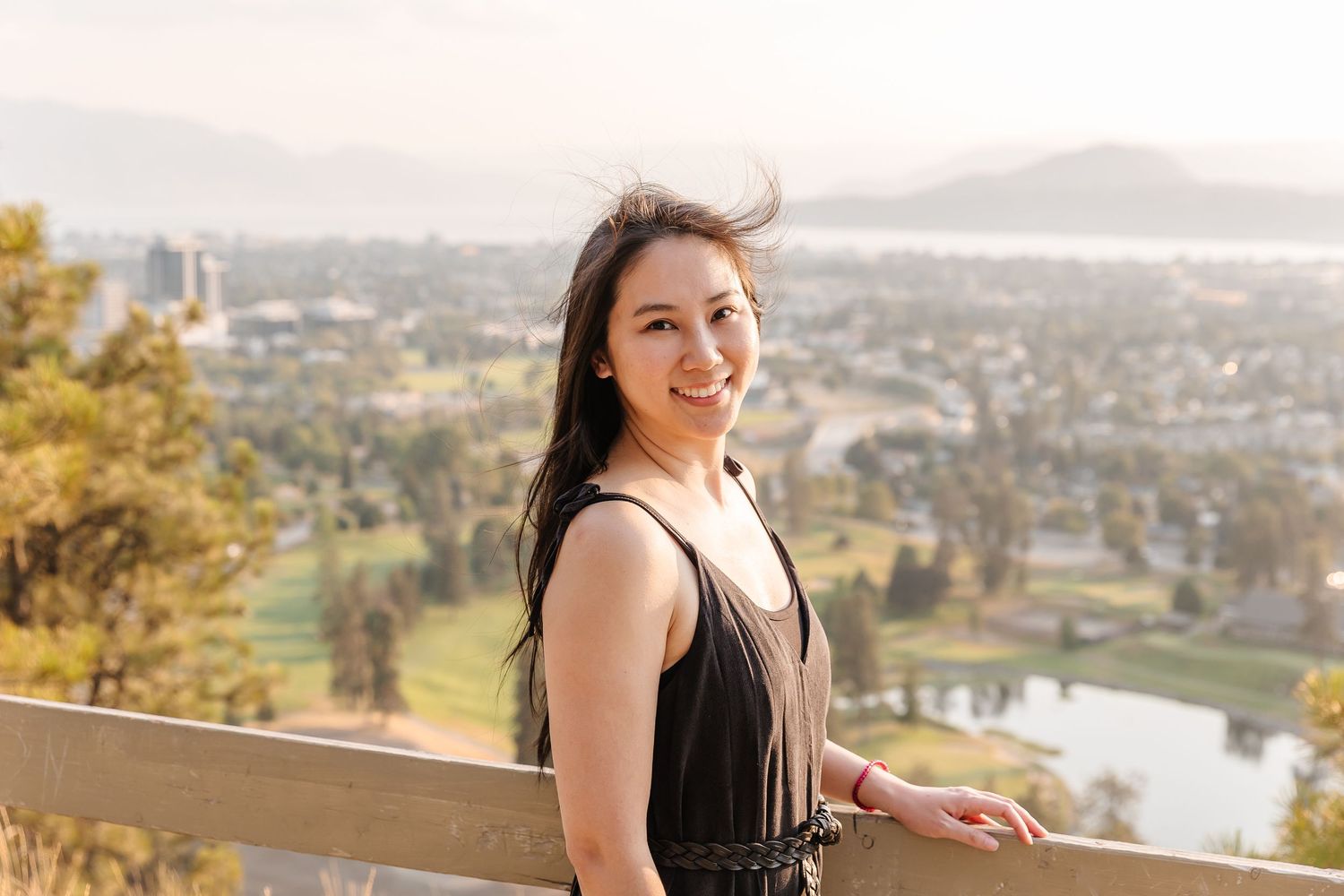 Scenic overlook views of a city with mountains and water in the background.