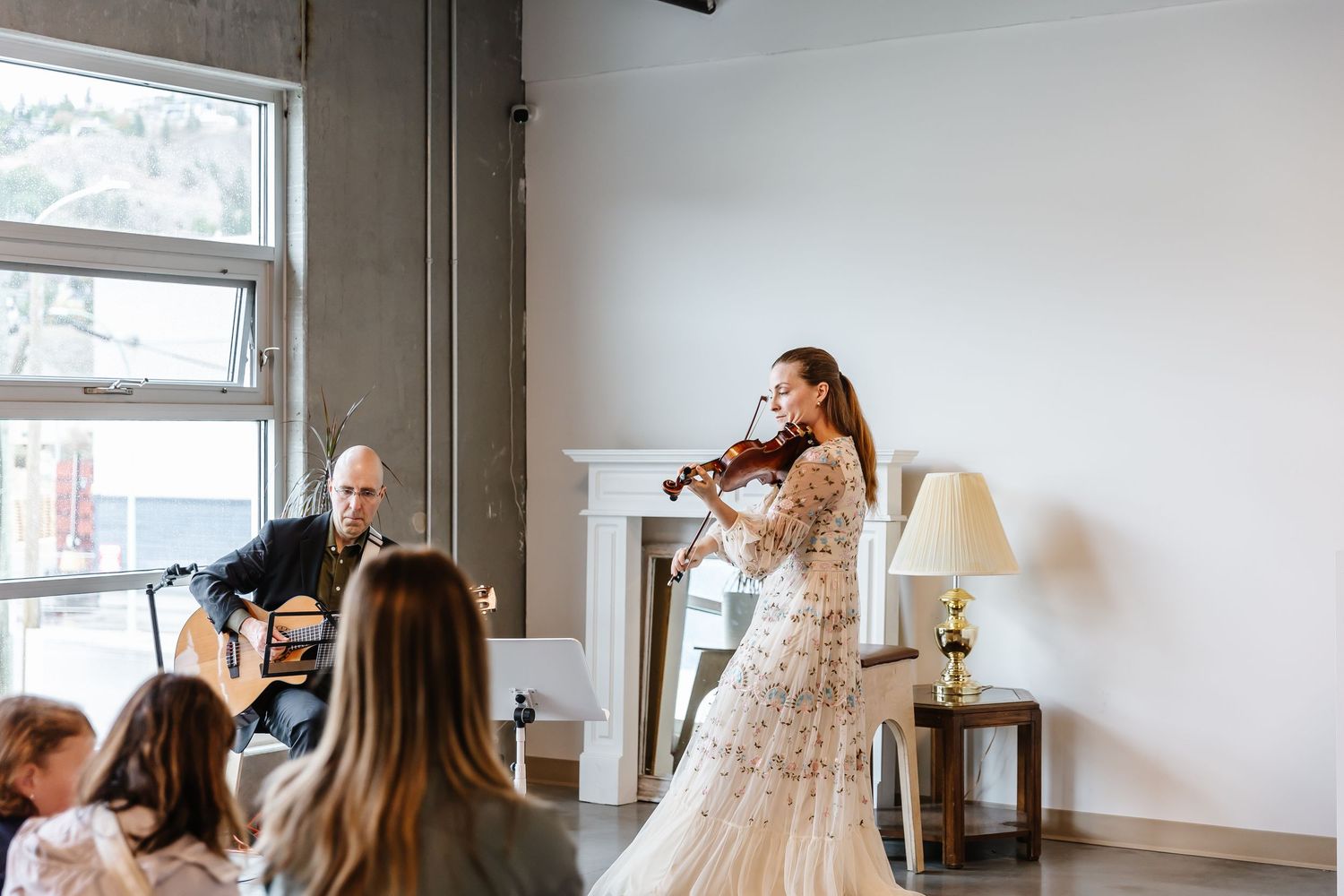A wedding dress boutique interior with natural light streaming through windows and elegant gowns on display.