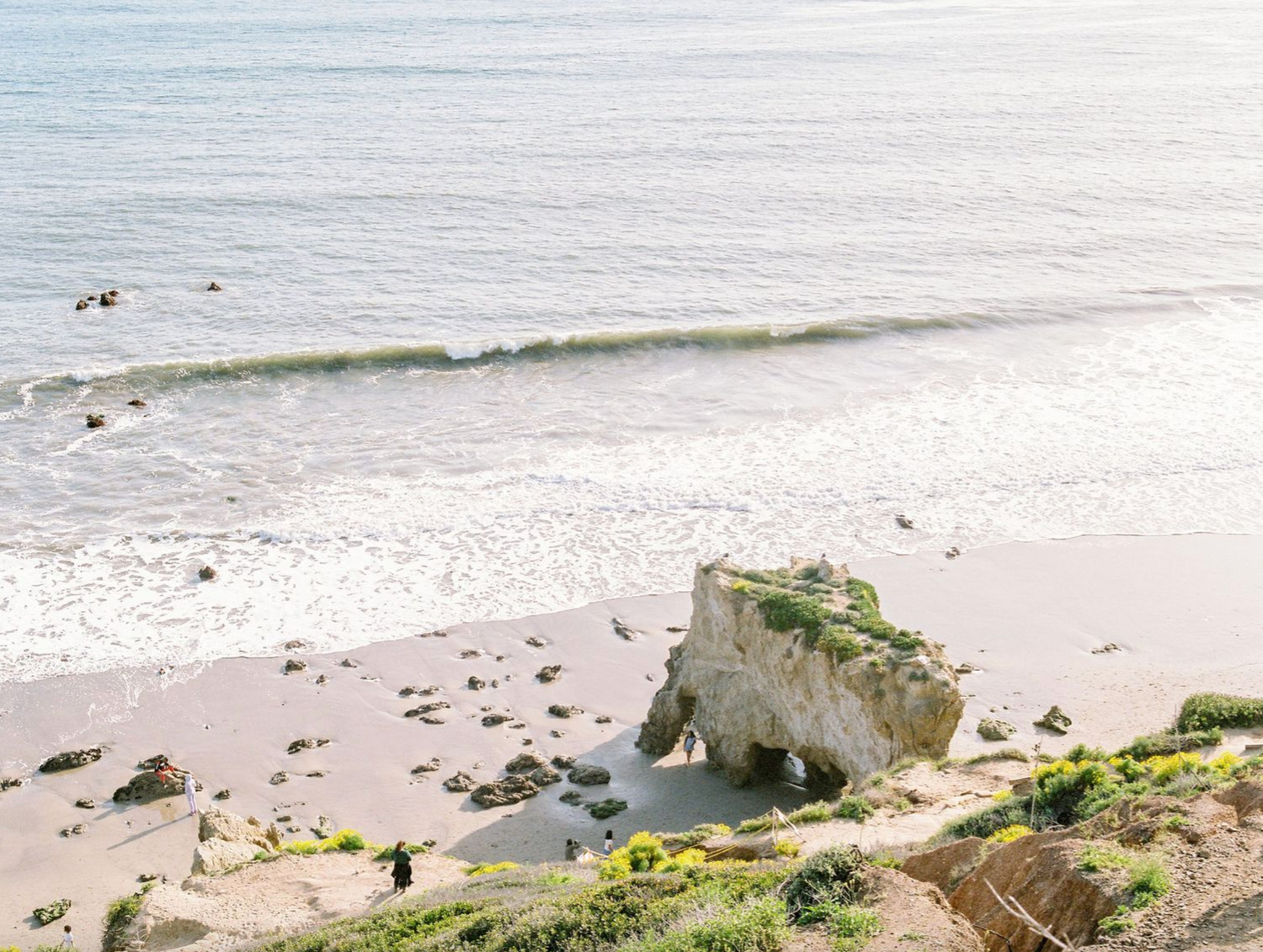 Scenic coastal view of a rocky beach with white cliffs and gentle waves rolling onto the shore.