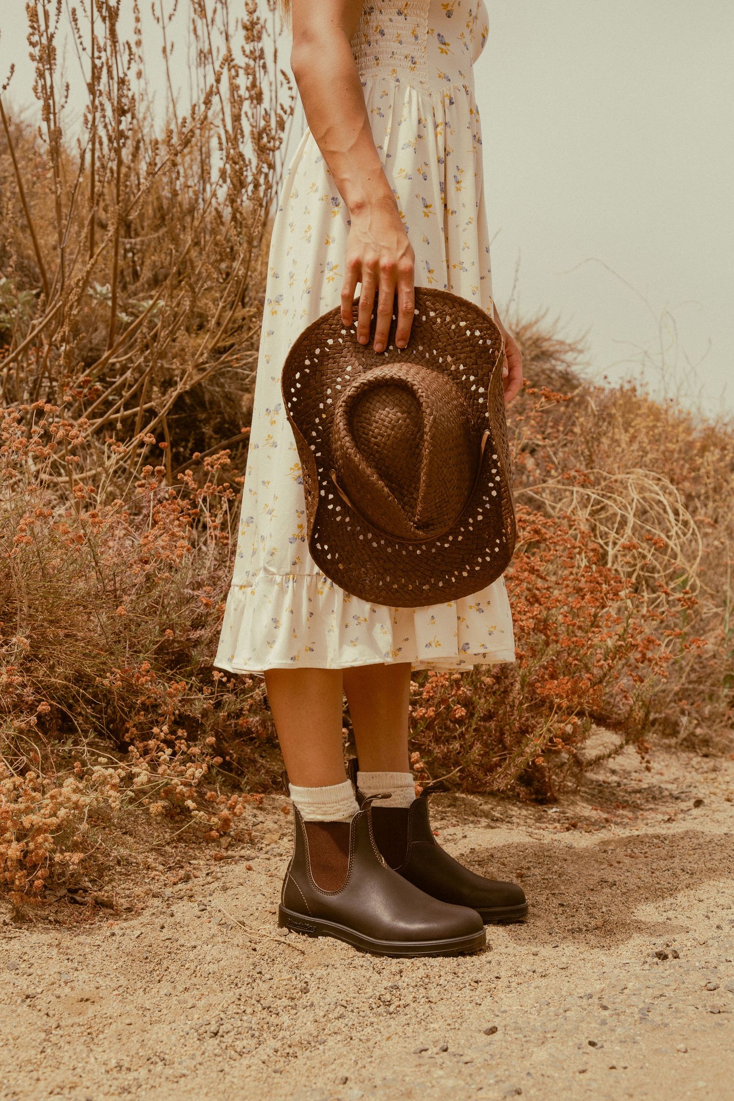 A sepia-toned photo series showing brown leather cowboy boots and a matching western hat against a rustic backdrop.