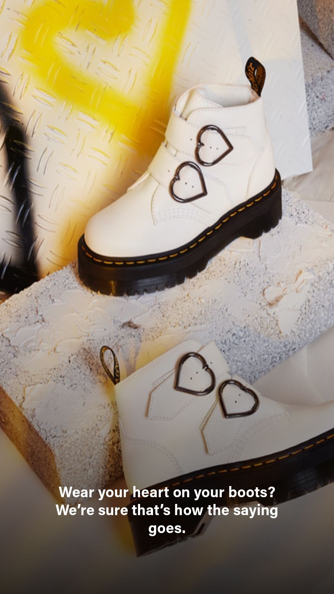 White boots with heart designs being customized with drawn heart shapes on the leather surface.