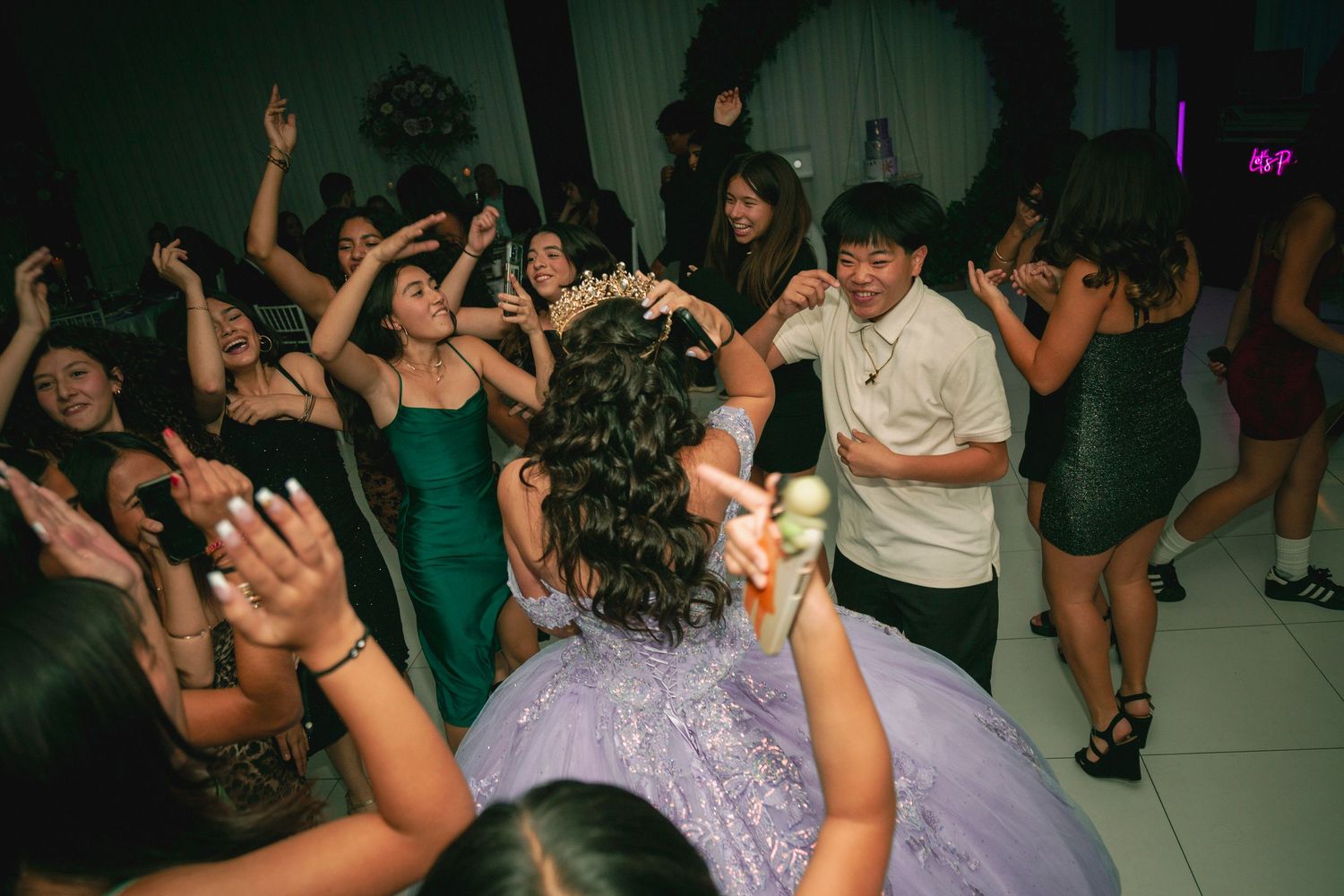 People dancing and enjoying themselves at a lively party with colorful lighting in a dark room.