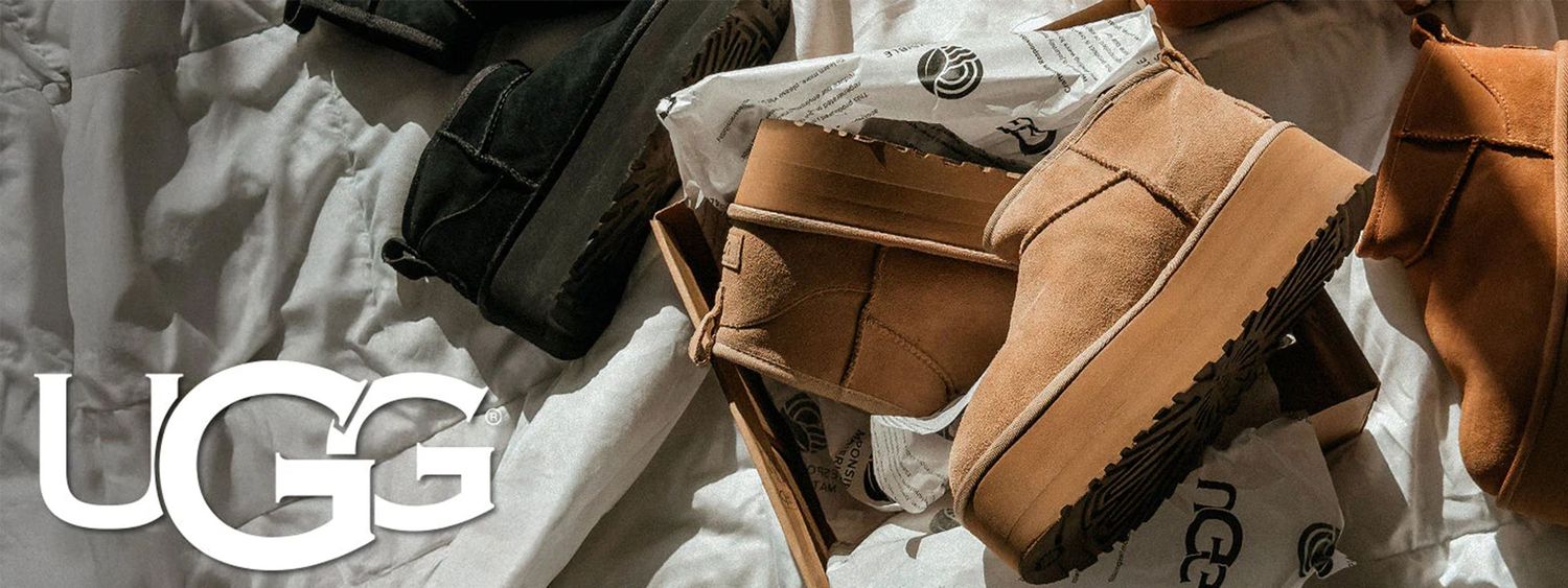 A row of brown UGG boots displayed on wooden shelves in a retail store setting.