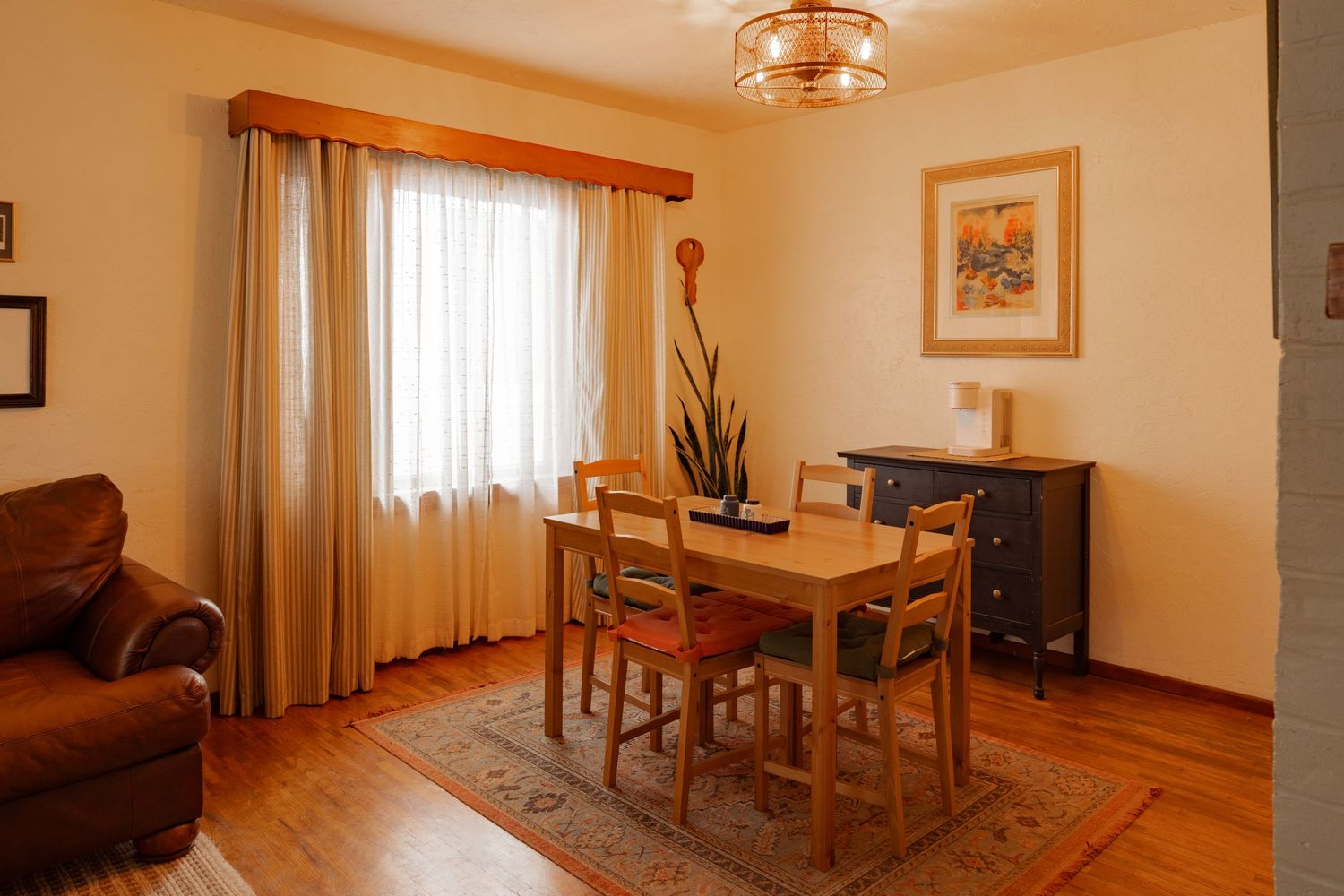 Warm-toned interior living space with wooden trim and furniture featuring natural light from multiple windows.