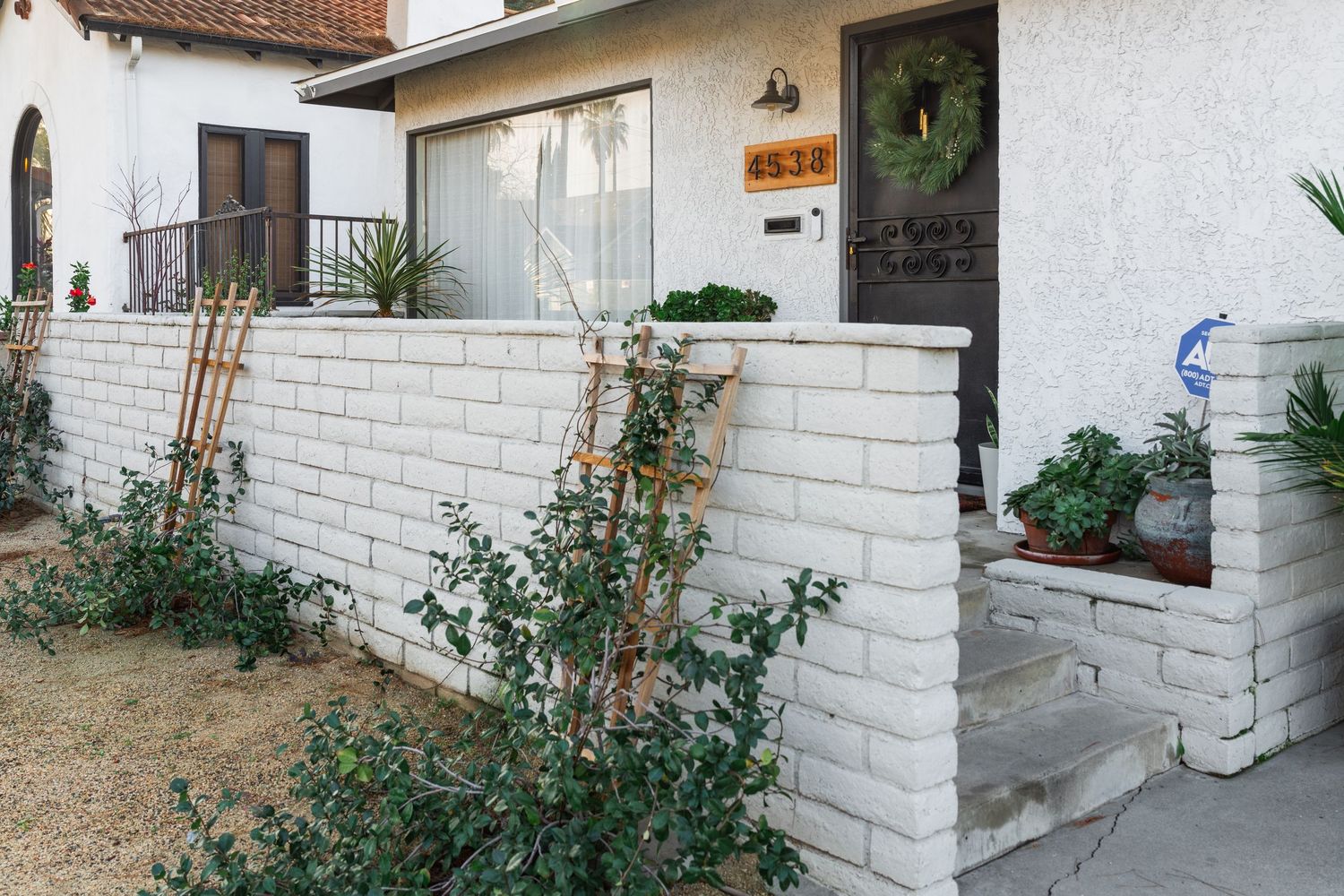 A series of white brick walls and garden spaces showing various outdoor patio and landscaping features.