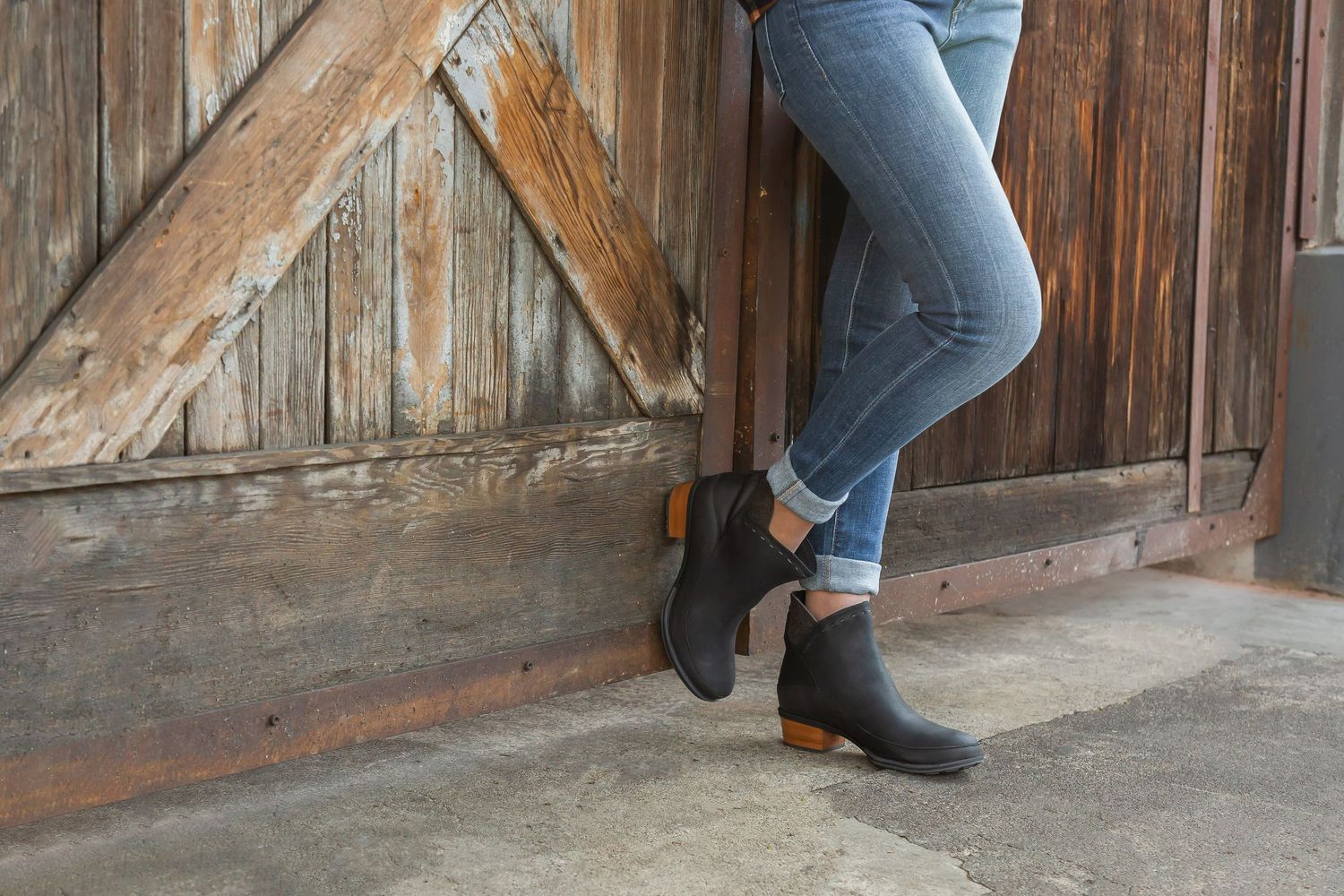 Close-up sequence of someone opening a rustic wooden barn door showing step-by-step sliding motion.