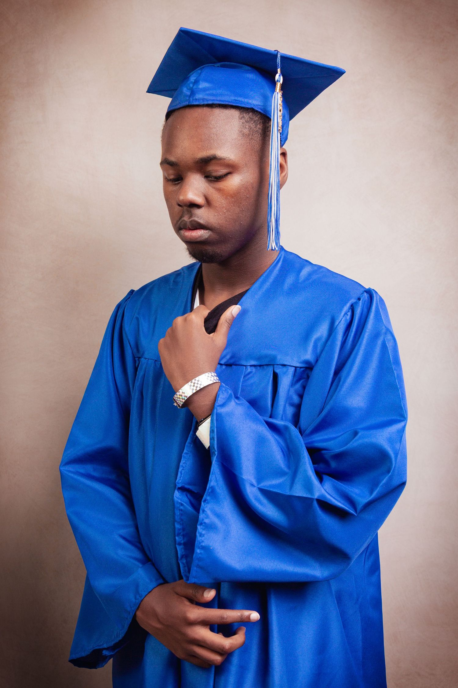 A series of photos showing a graduate in a bright blue cap and gown striking contemplative poses.