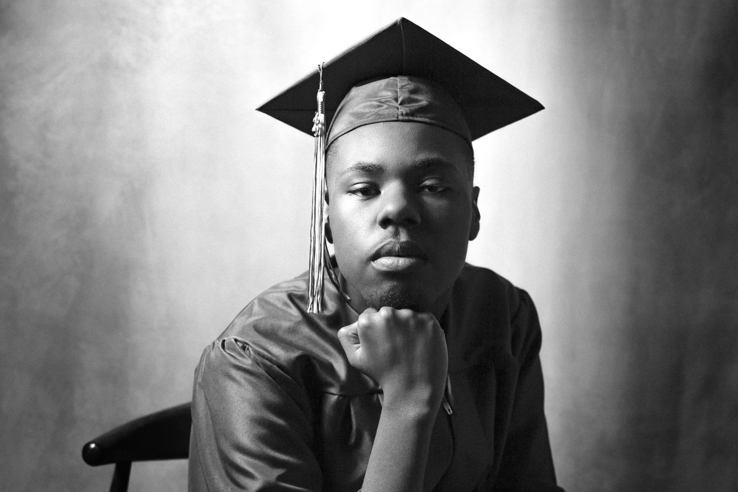 Black and white graduation portrait series showing a graduate in academic regalia from different angles.