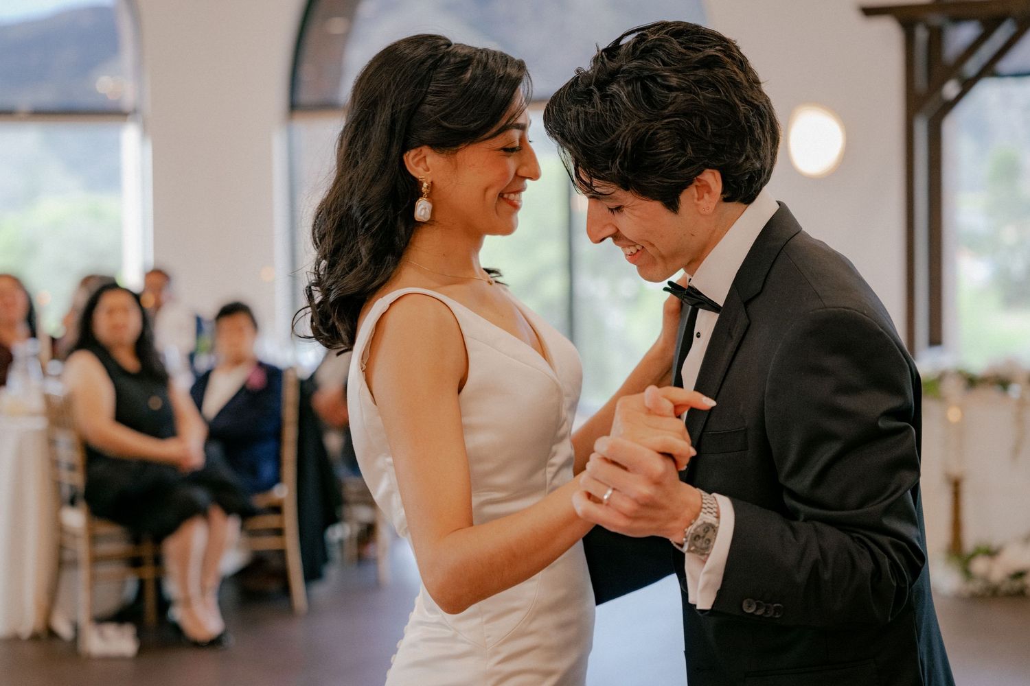 A couple dances together in a romantic moment at an indoor wedding venue.