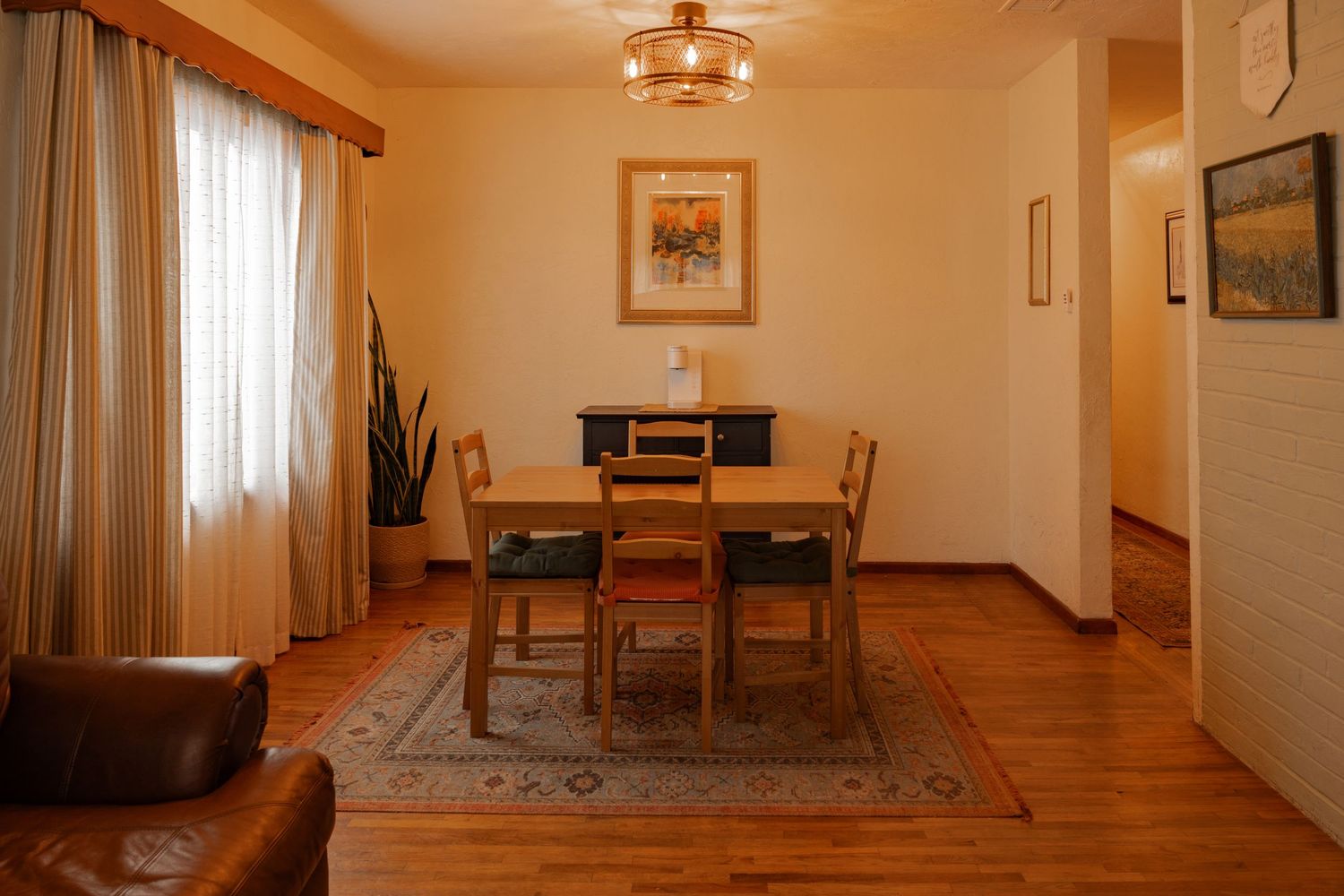 A warm-toned interior hallway with hardwood floors, beige walls, and pendant lighting showcases classic home decor elements.