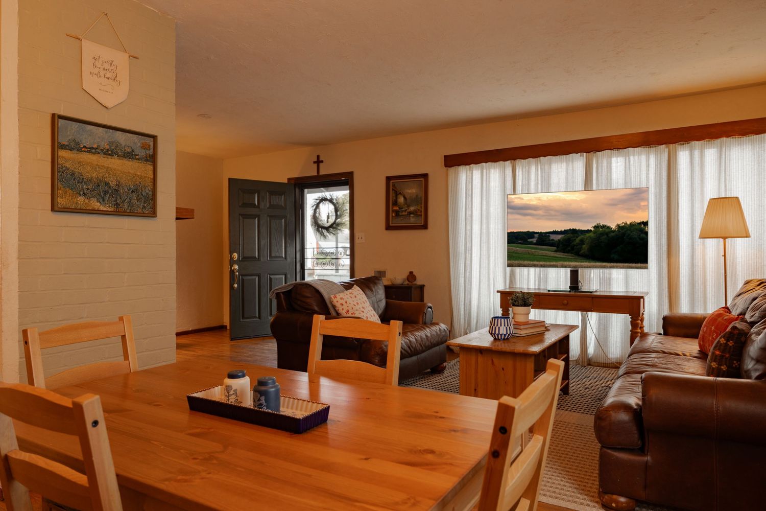 Cozy living room interior with wooden dining table and warm lighting showcases modern Scandinavian design elements.