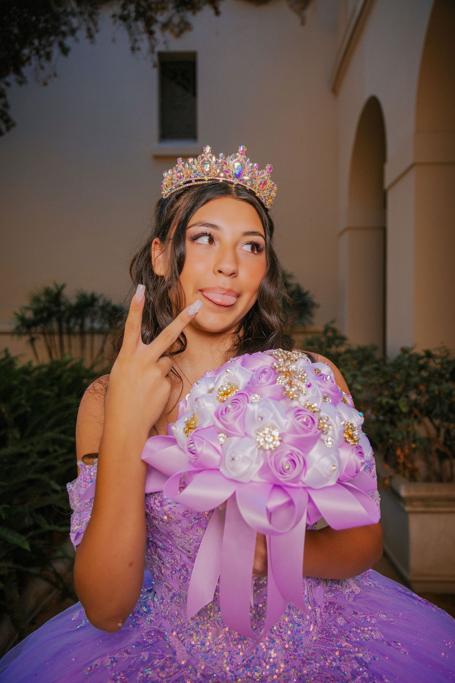 A quinceañera celebration featuring a lavender ball gown with intricate details and a sparkly tiara.