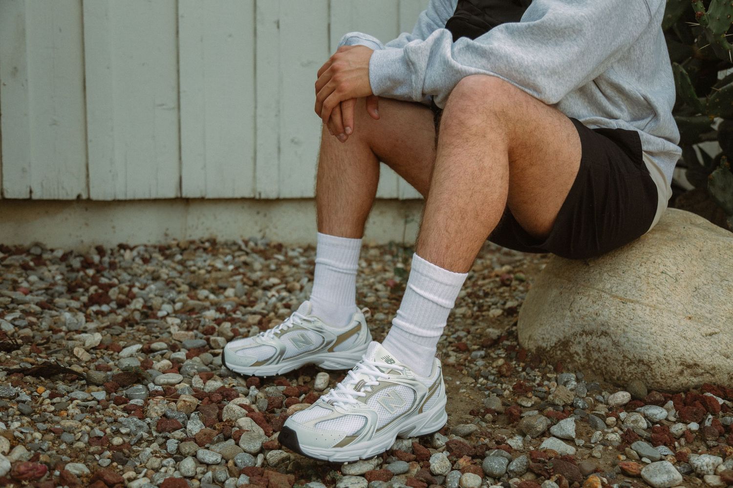 A collection of six cropped photos showing white sneakers and socks from different angles on a gravel surface.