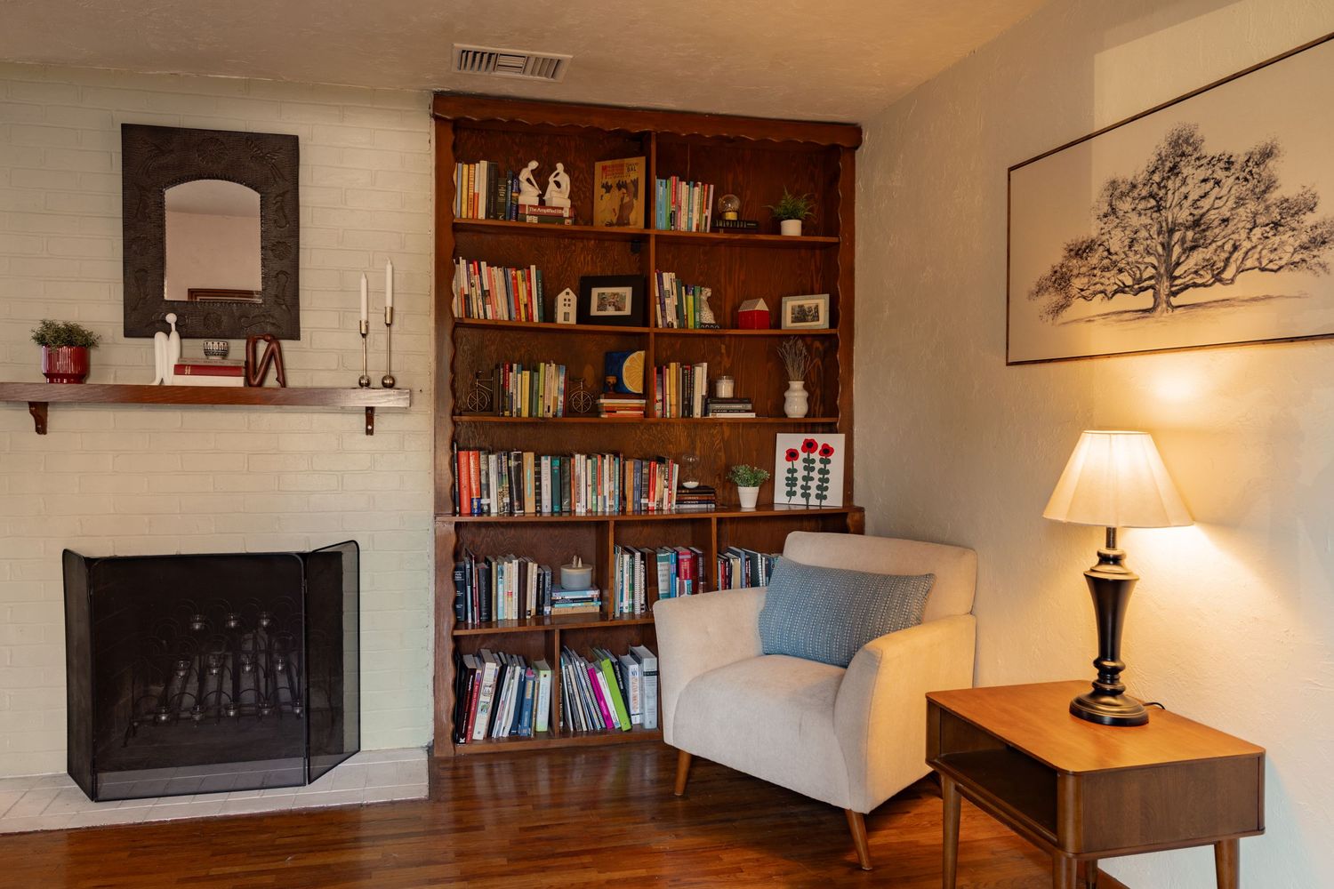 A panoramic view of a modern living room with wooden bookshelves, warm lighting, and decorative wall accents.