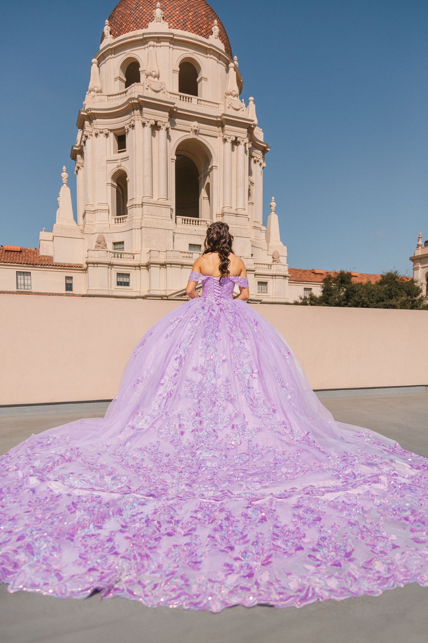 A lavender ballgown with a flowing train photographed in front of Pasadena City Hall's iconic dome architecture.