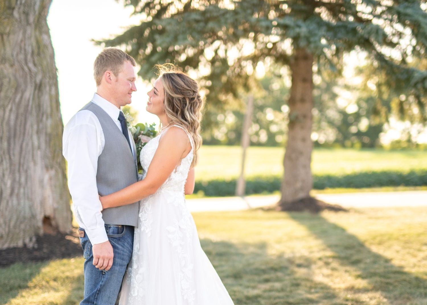 A romantic outdoor wedding photoshoot showing tender moments between a couple in formal attire.