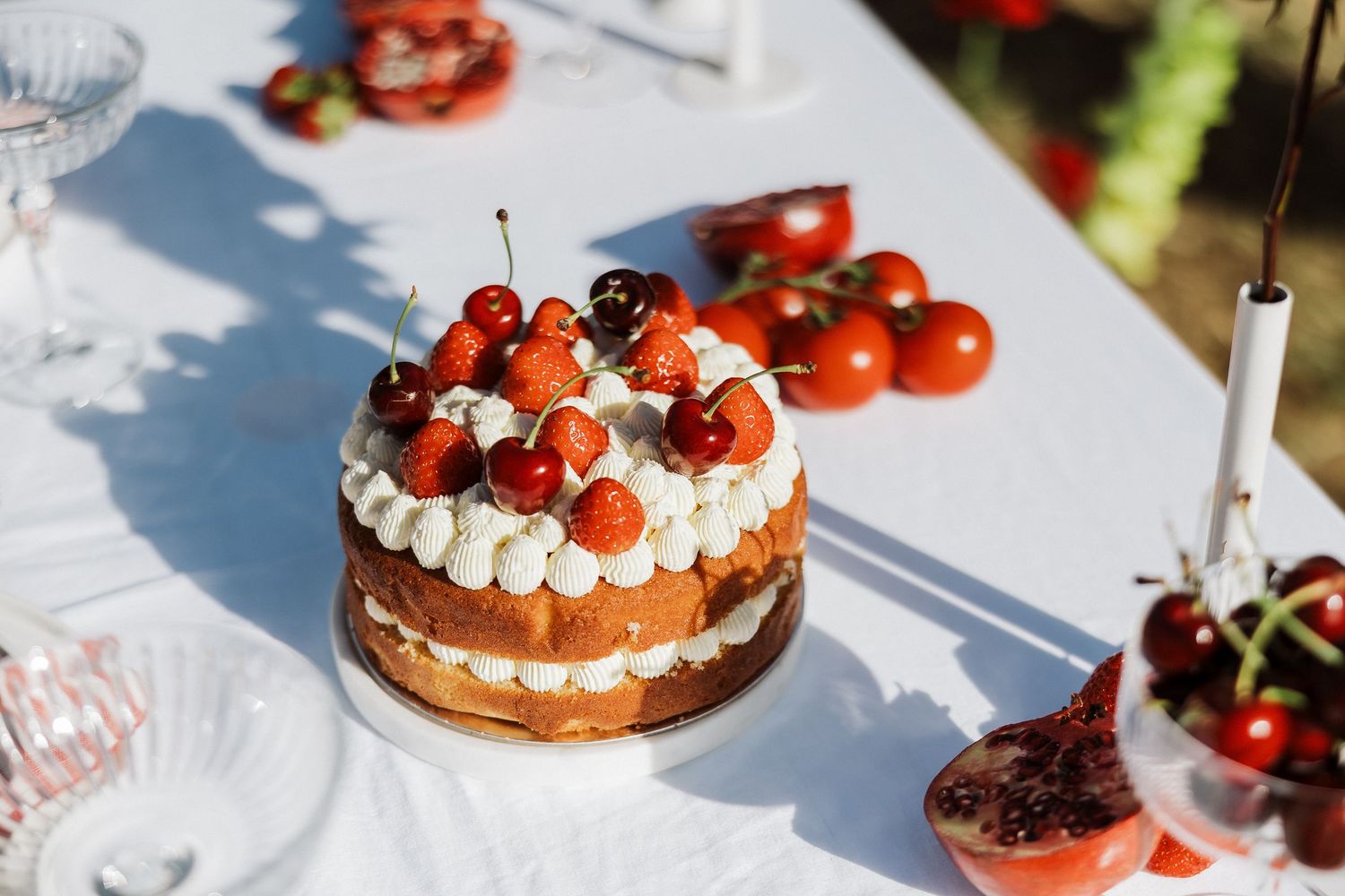 Fresh strawberries and cream garnish a chocolate dessert on elegant white plates.