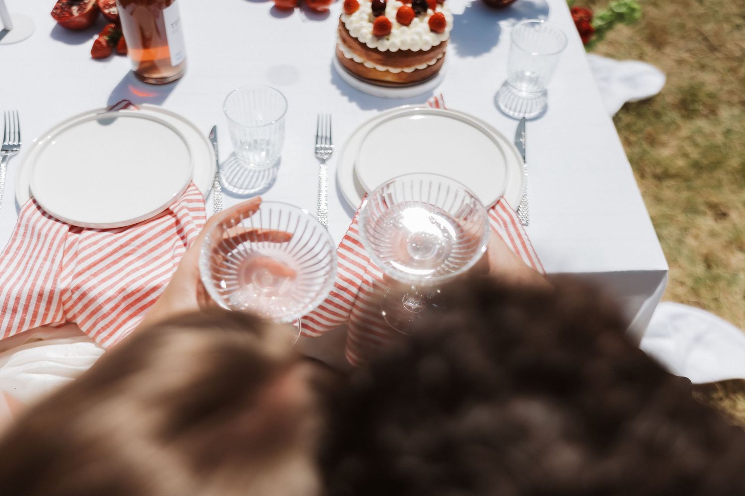 A group of people gathered around a table with wine glasses and desserts for a casual dining experience.