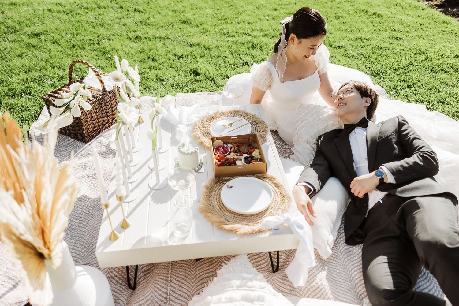 A couple in wedding attire shares an intimate moment during their outdoor garden reception celebration.