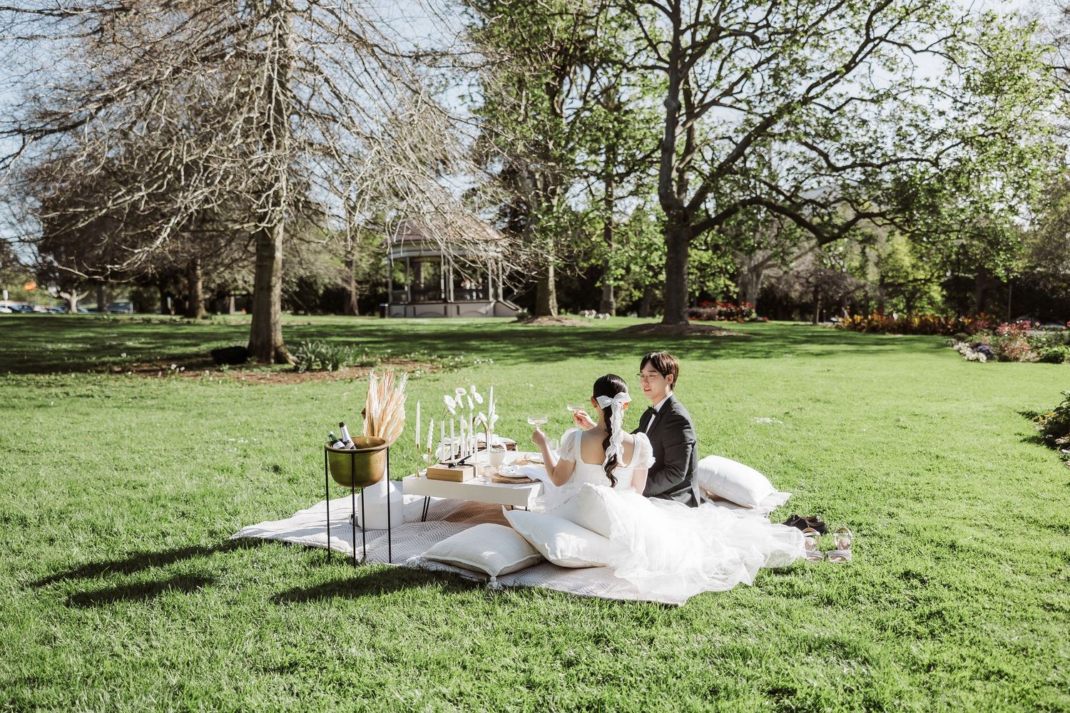 Elegant outdoor wedding ceremony setup with white chairs and floral arrangements in a lush garden setting.