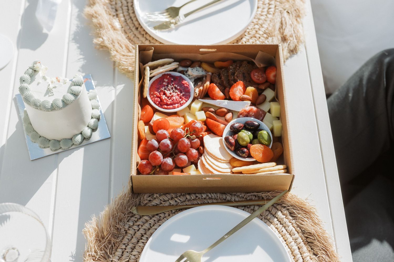 Wedding reception table with rustic wooden boxes filled with fresh berries and elegant place settings.