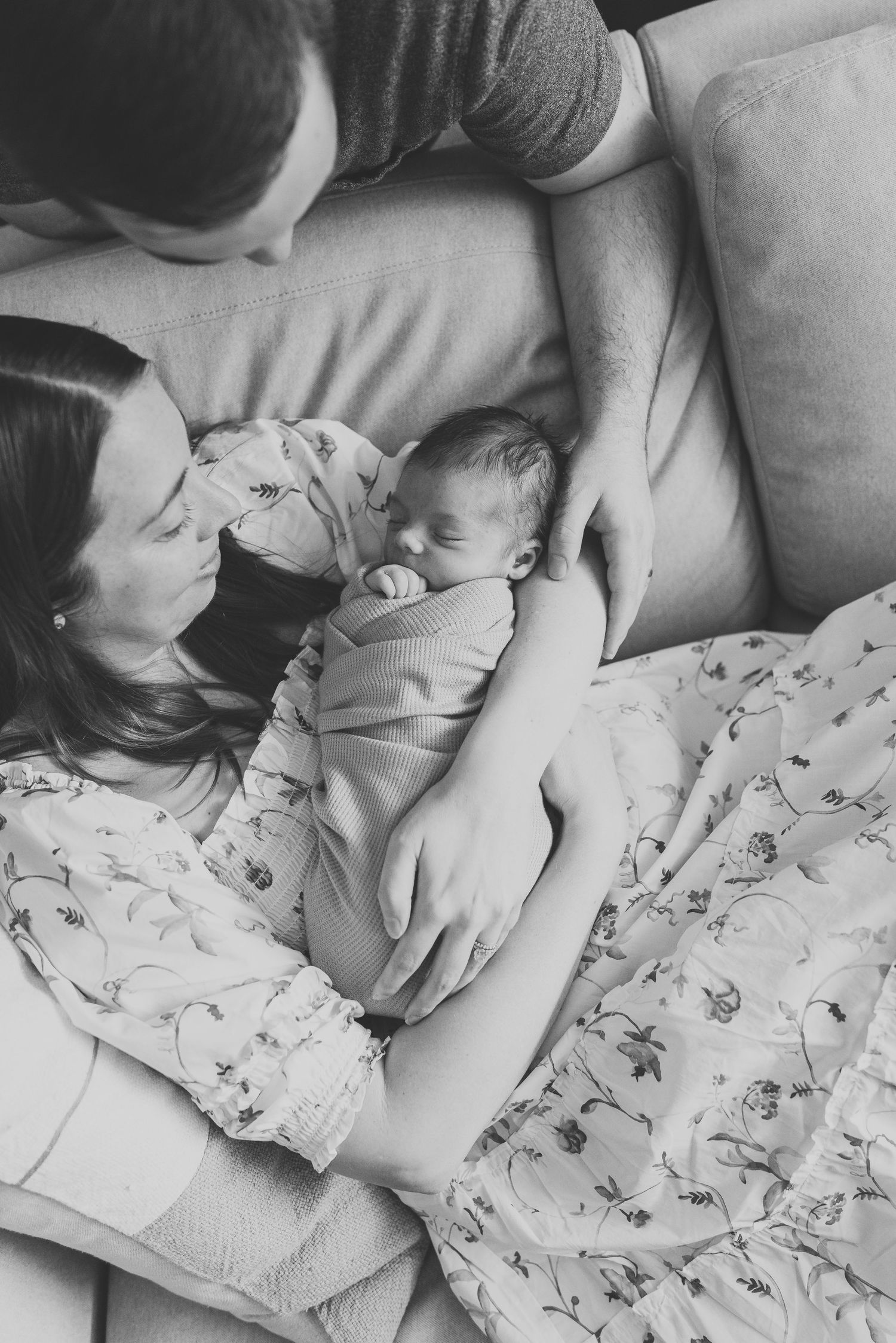 Close-up of sleeping newborn in mother's arms in a black and white image by Lauren Marie photography.