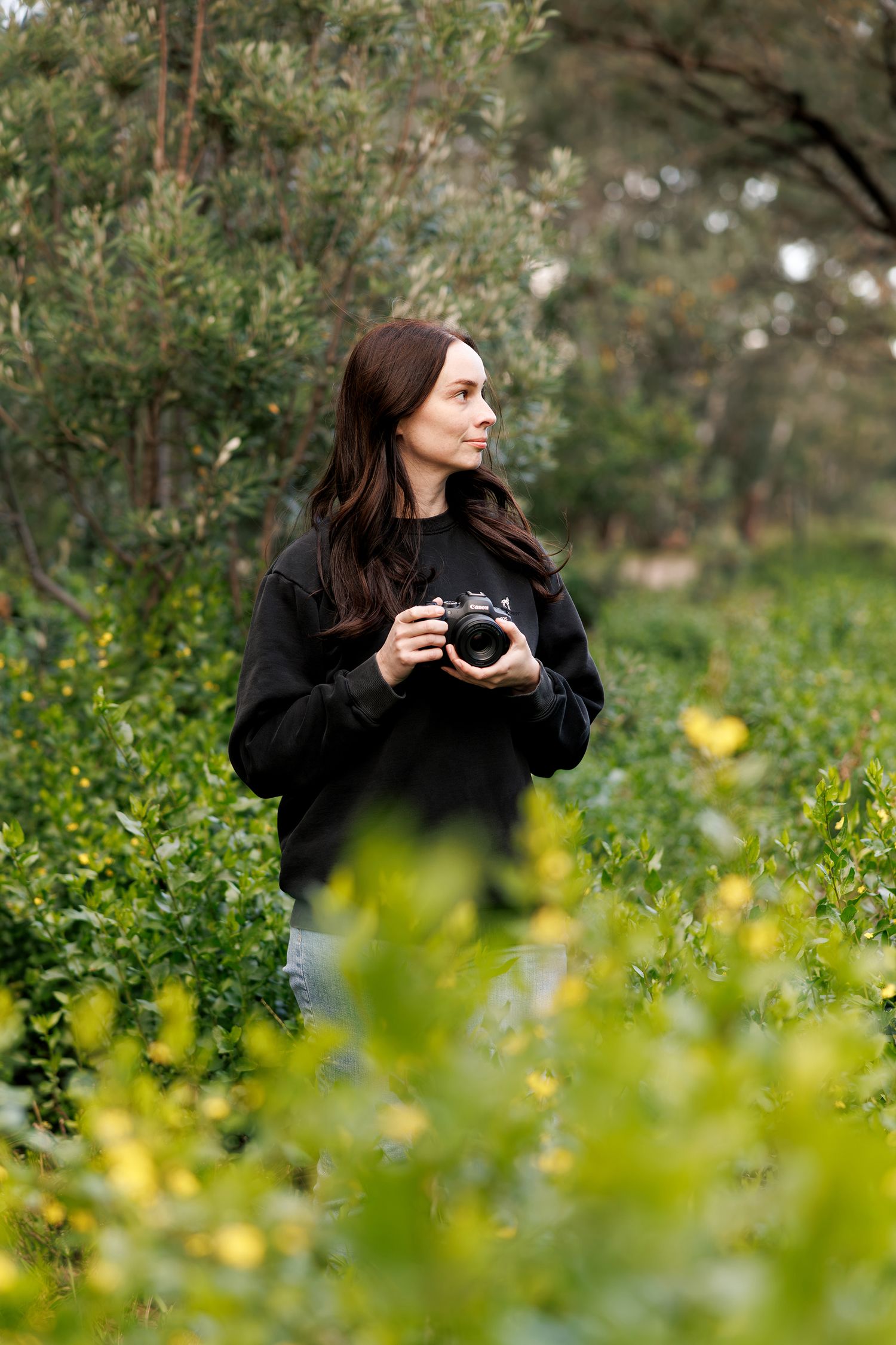 Photographer standing amongst spring blooms in Melbourne park