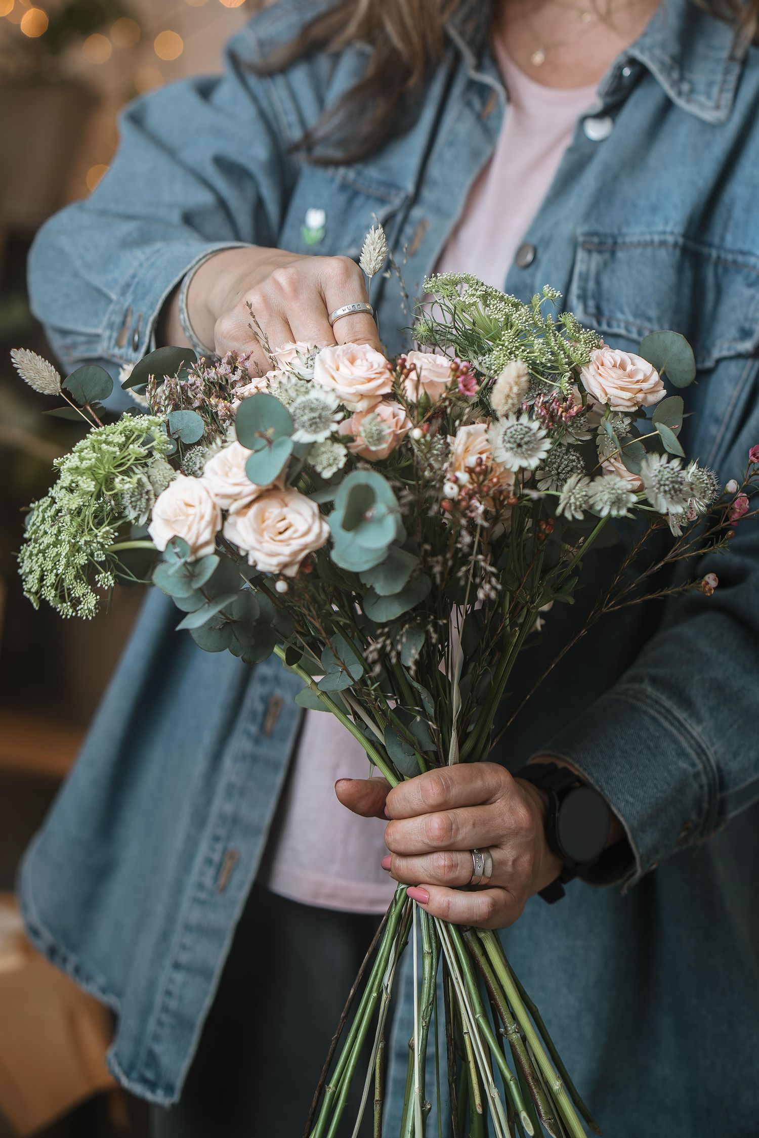 Florist arbetar med blomsterarrangemang under varumärkesfotografering
