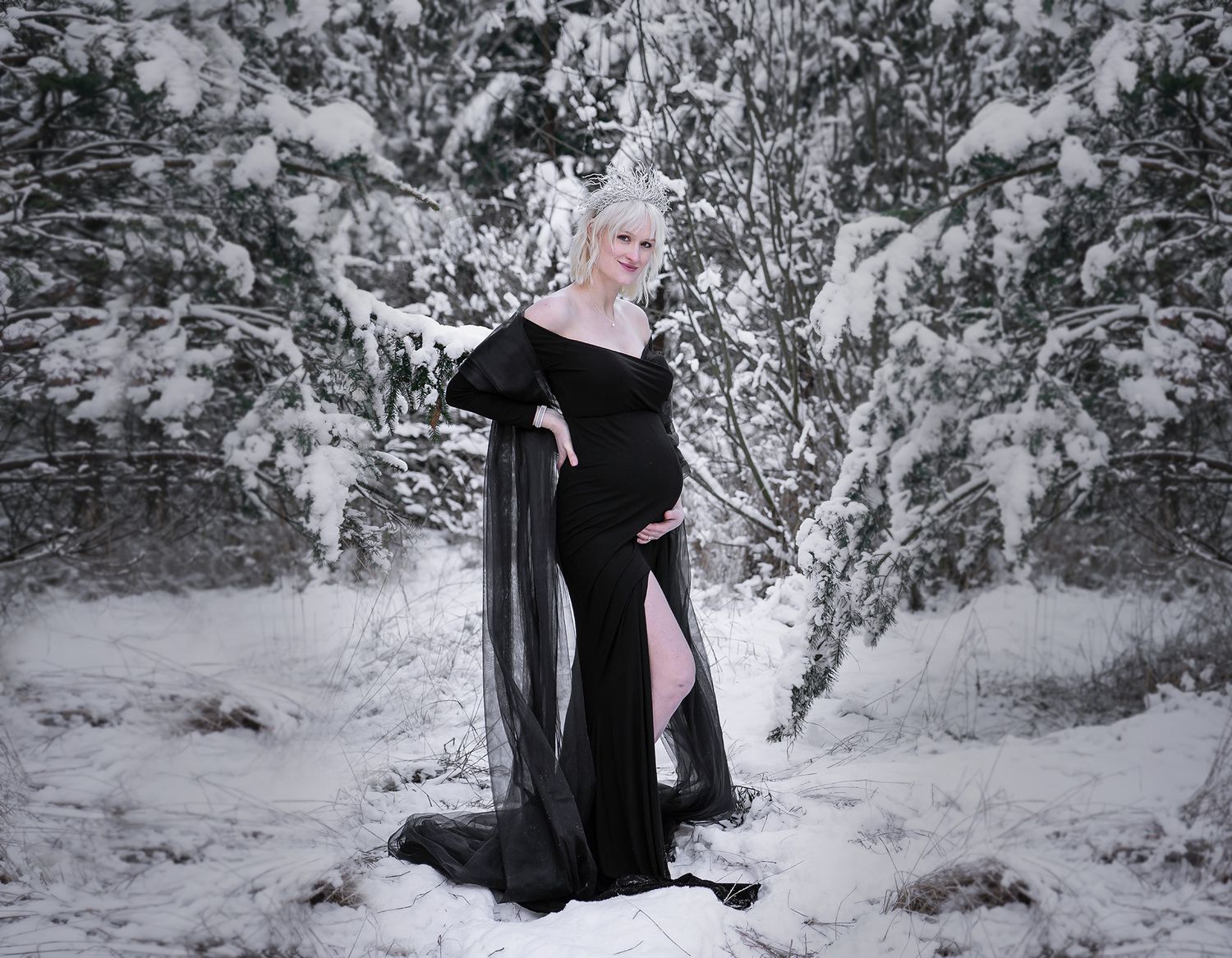 Gravidfotografering i Uppsala med kvinna i svart klänning vintertid