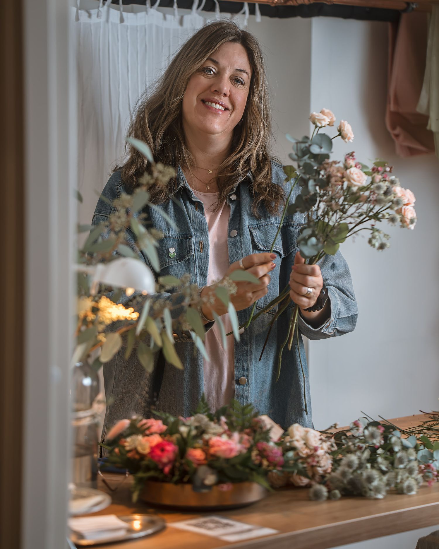 Företagare och florist håller en bukett blommor inomhus under varumärkesfotografering