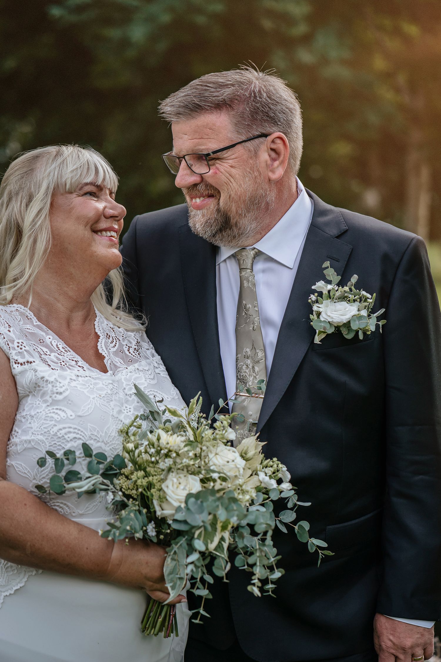 Anna och Stefan ler mot varandra under porträttfotograferingen efter vigseln på Rånäs Slott.