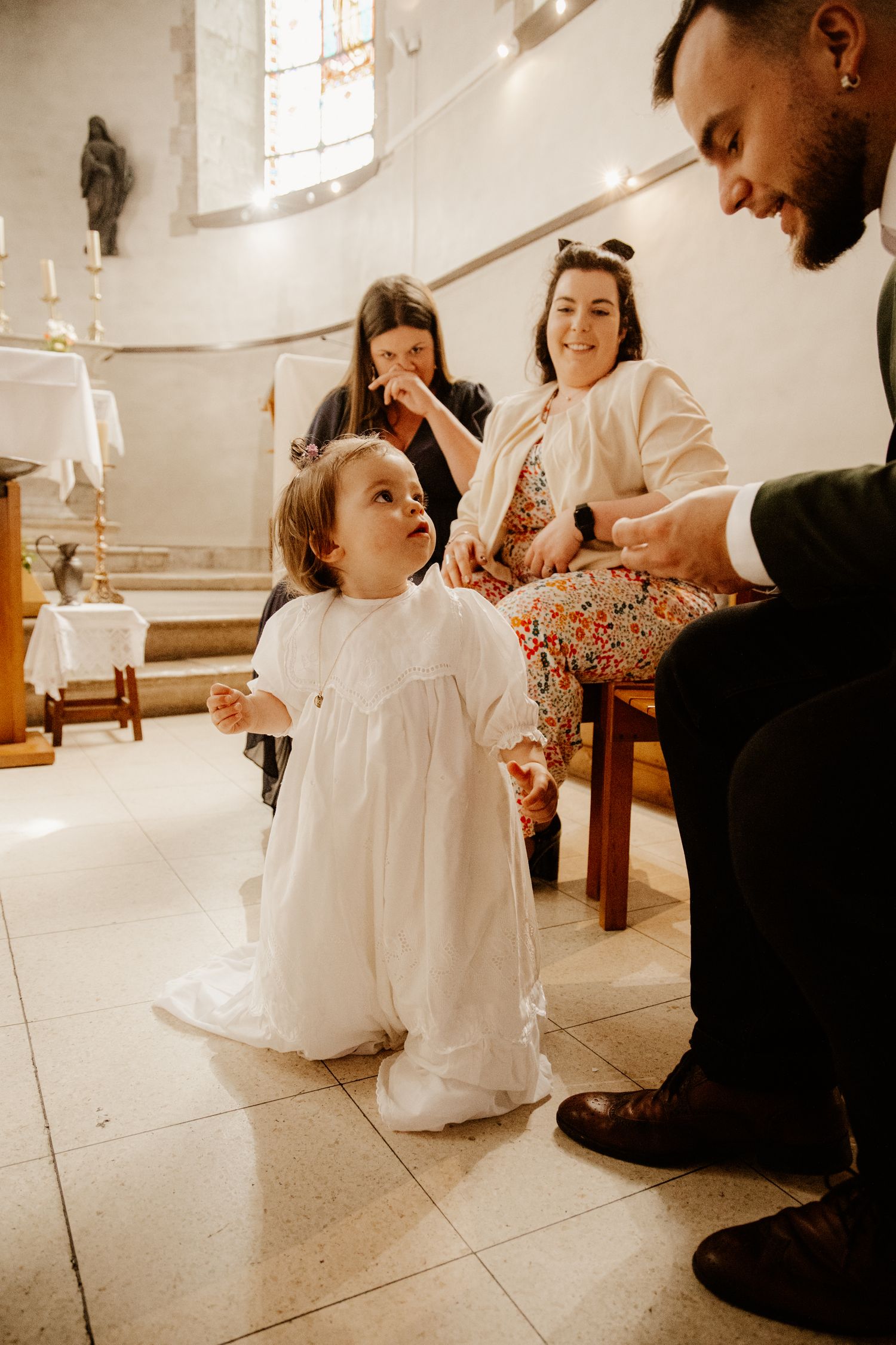 petite fils qui regarde son parrain pendant son baptême