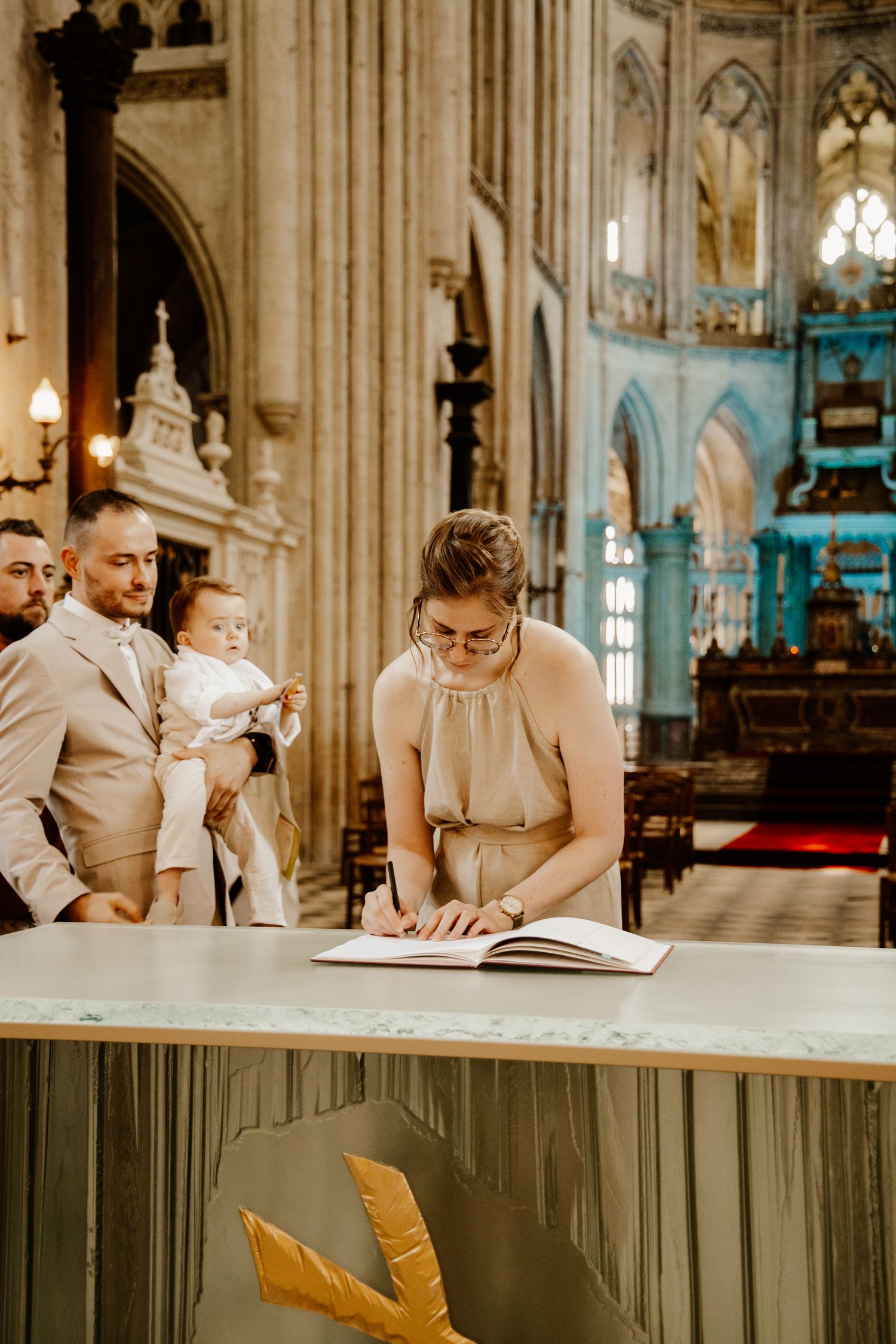 maman qui signe les papiers du baptême de son fils à l'église